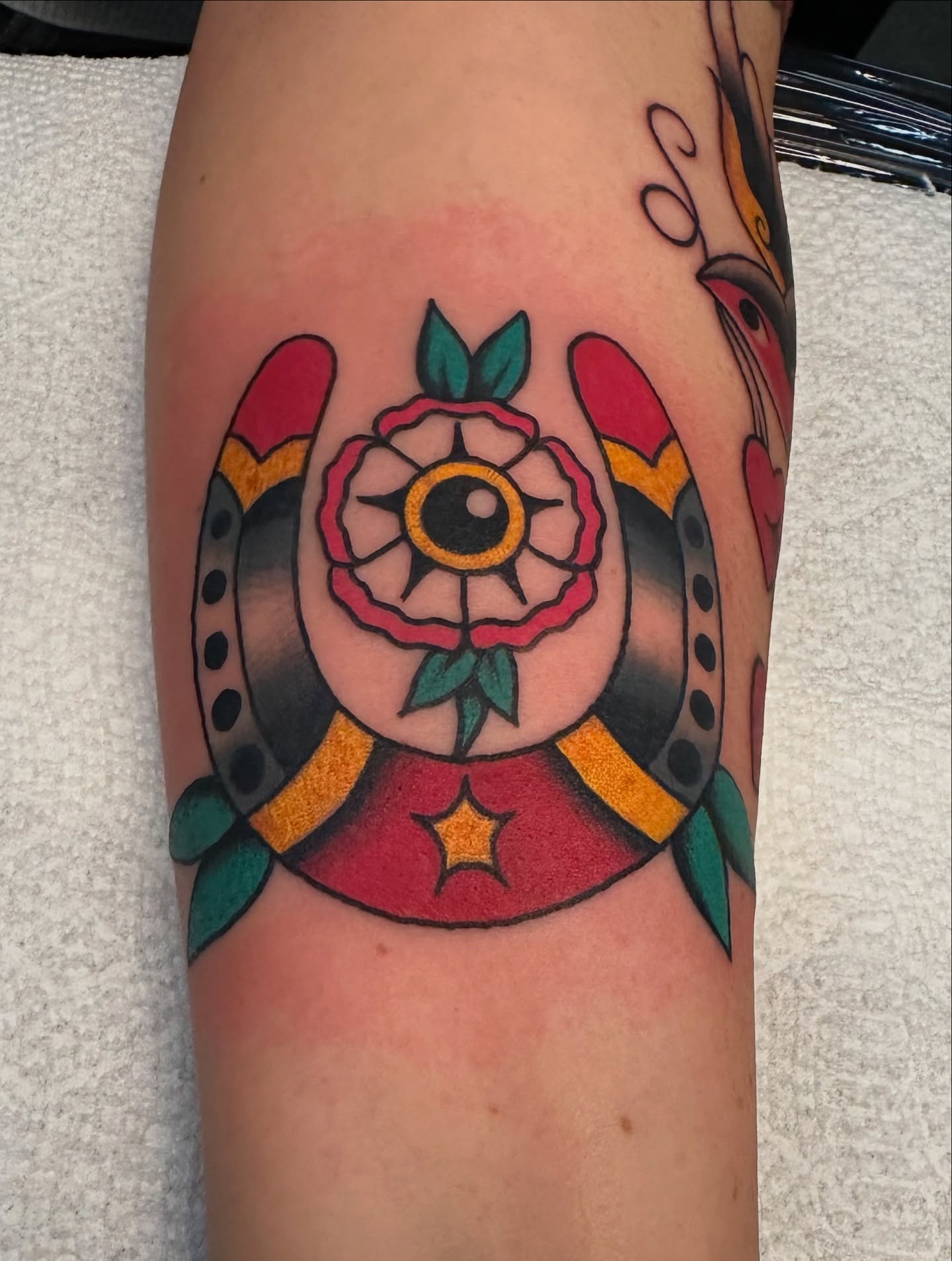 Rose and horseshoe American traditional tattoo on the forearm by Emily Masa