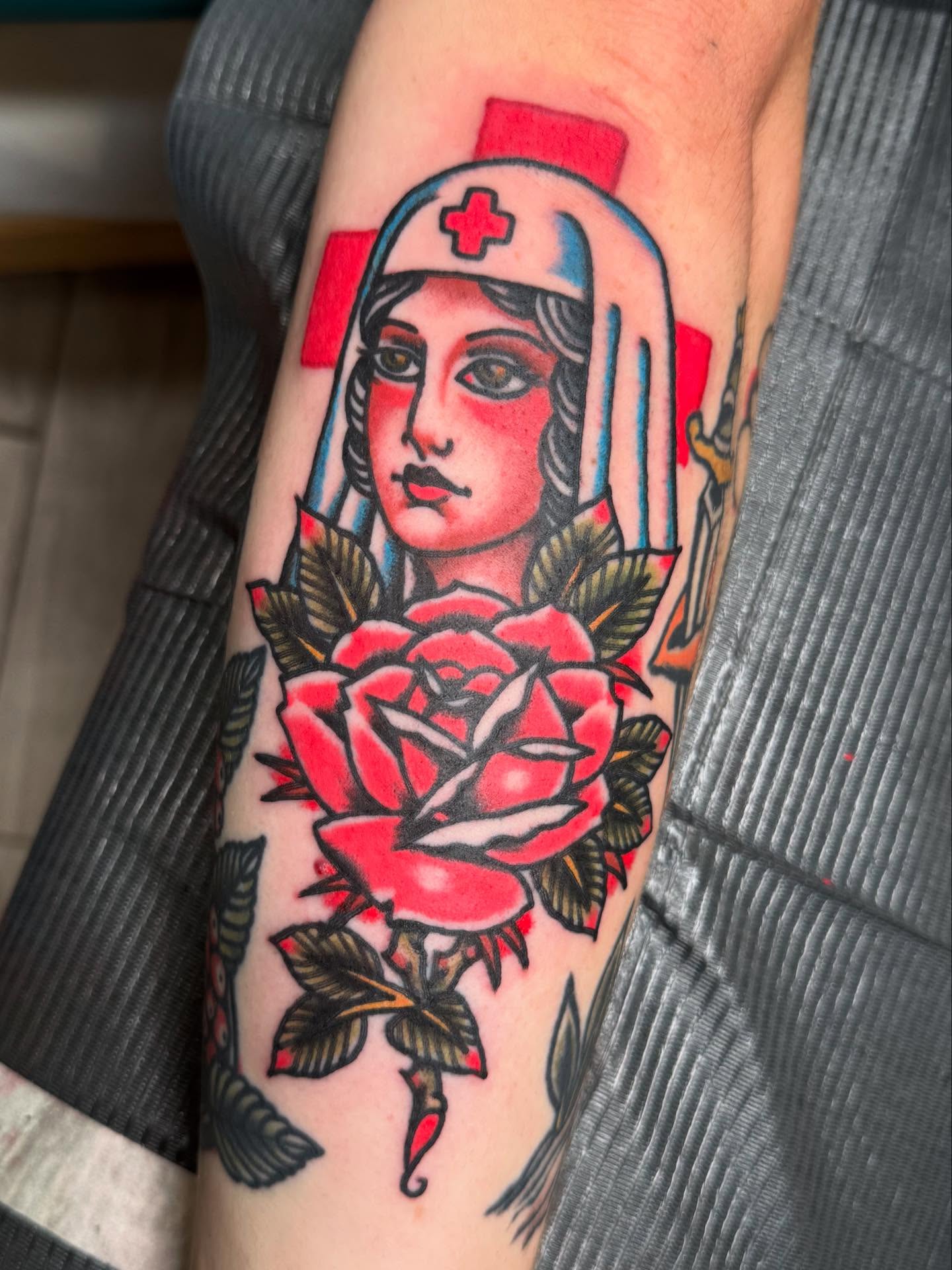 Nurse with roses American traditional tattoo on the forearm by Bill Crawford, Plymouth, Michigan