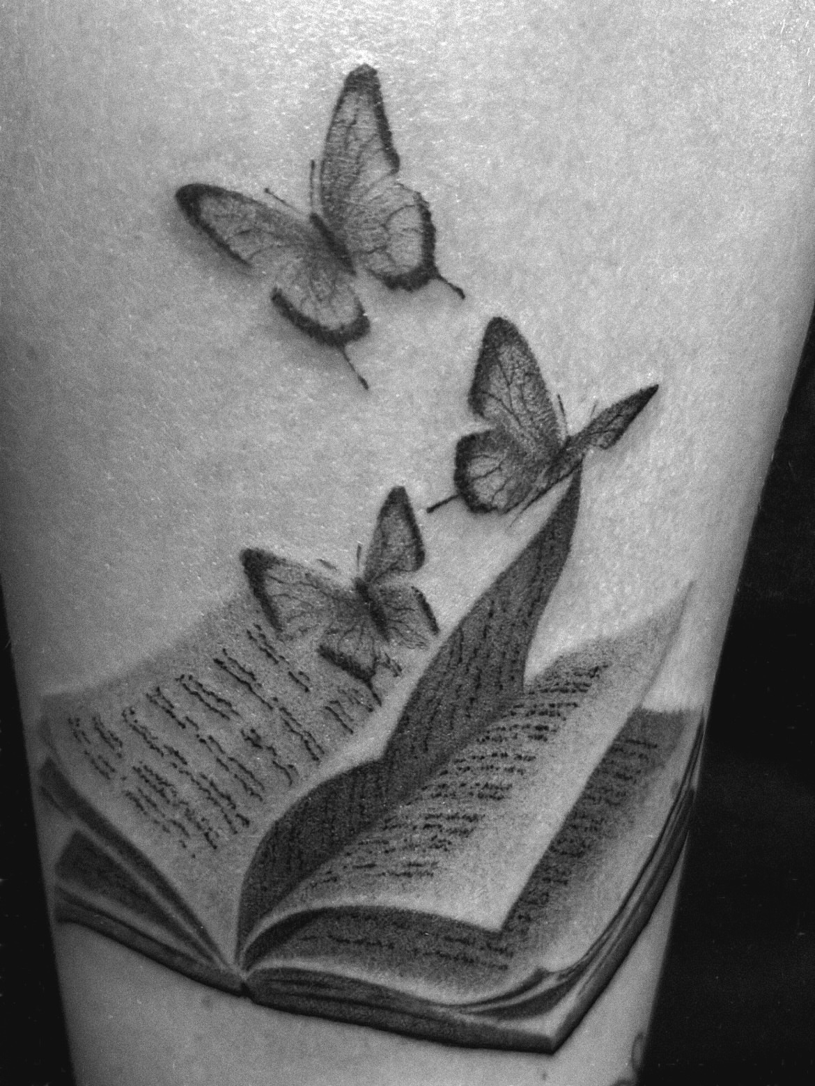 Book and butterflies realism tattoo on the forearm by Roman Butryy