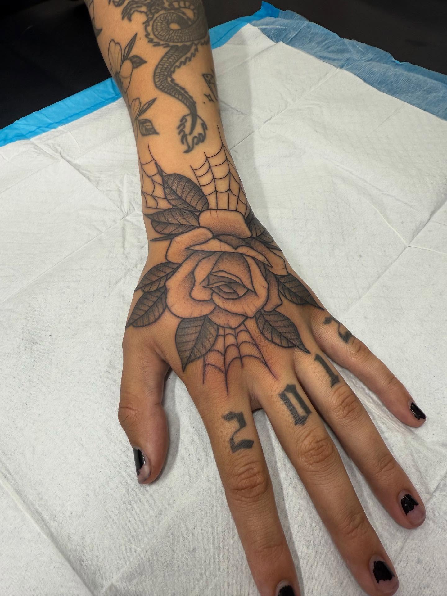 Rose and dragon American traditional tattoo on the hand by Maddie Jo DeYoung