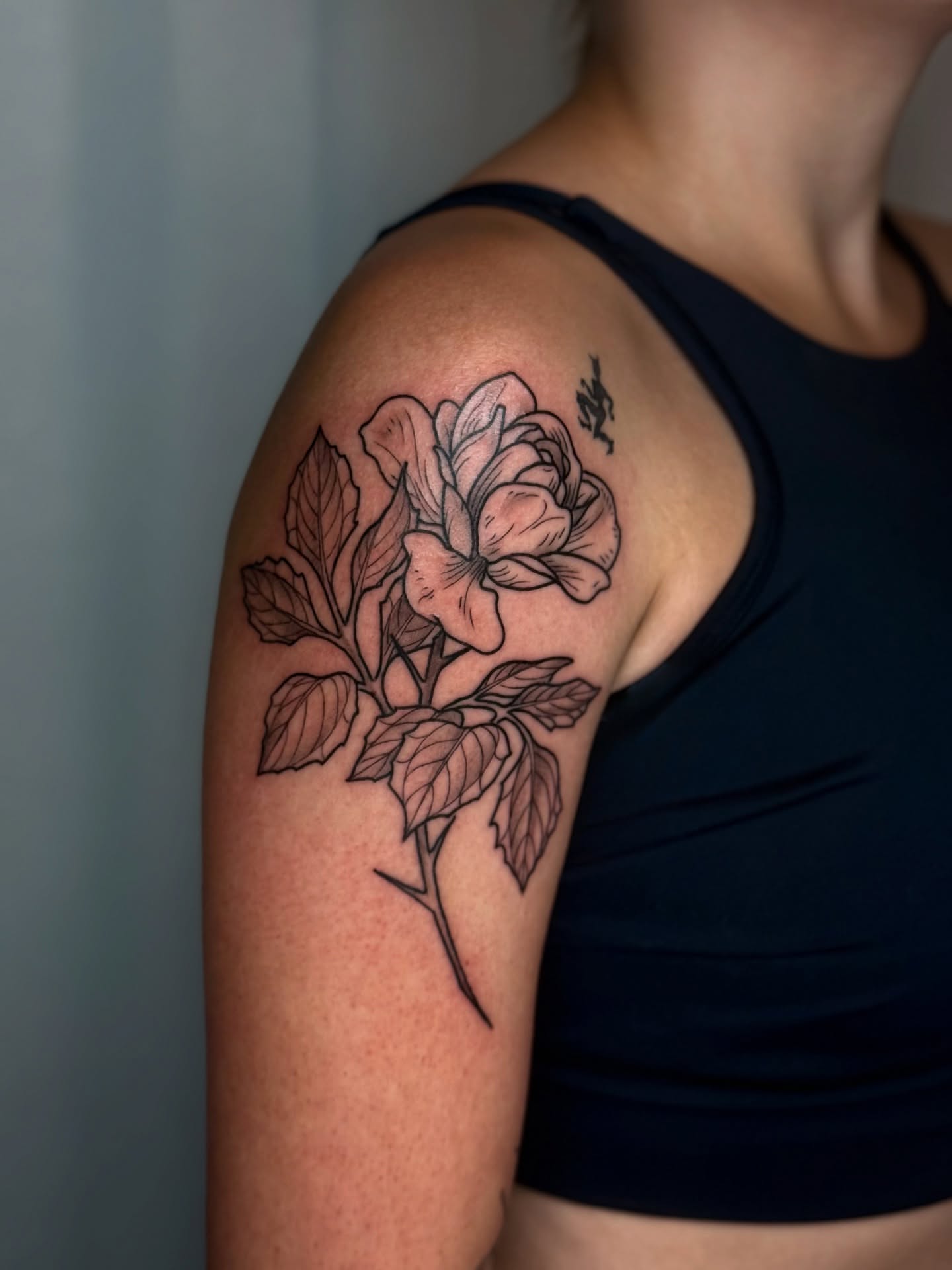 Rose black and grey tattoo on the shoulder by Cooper