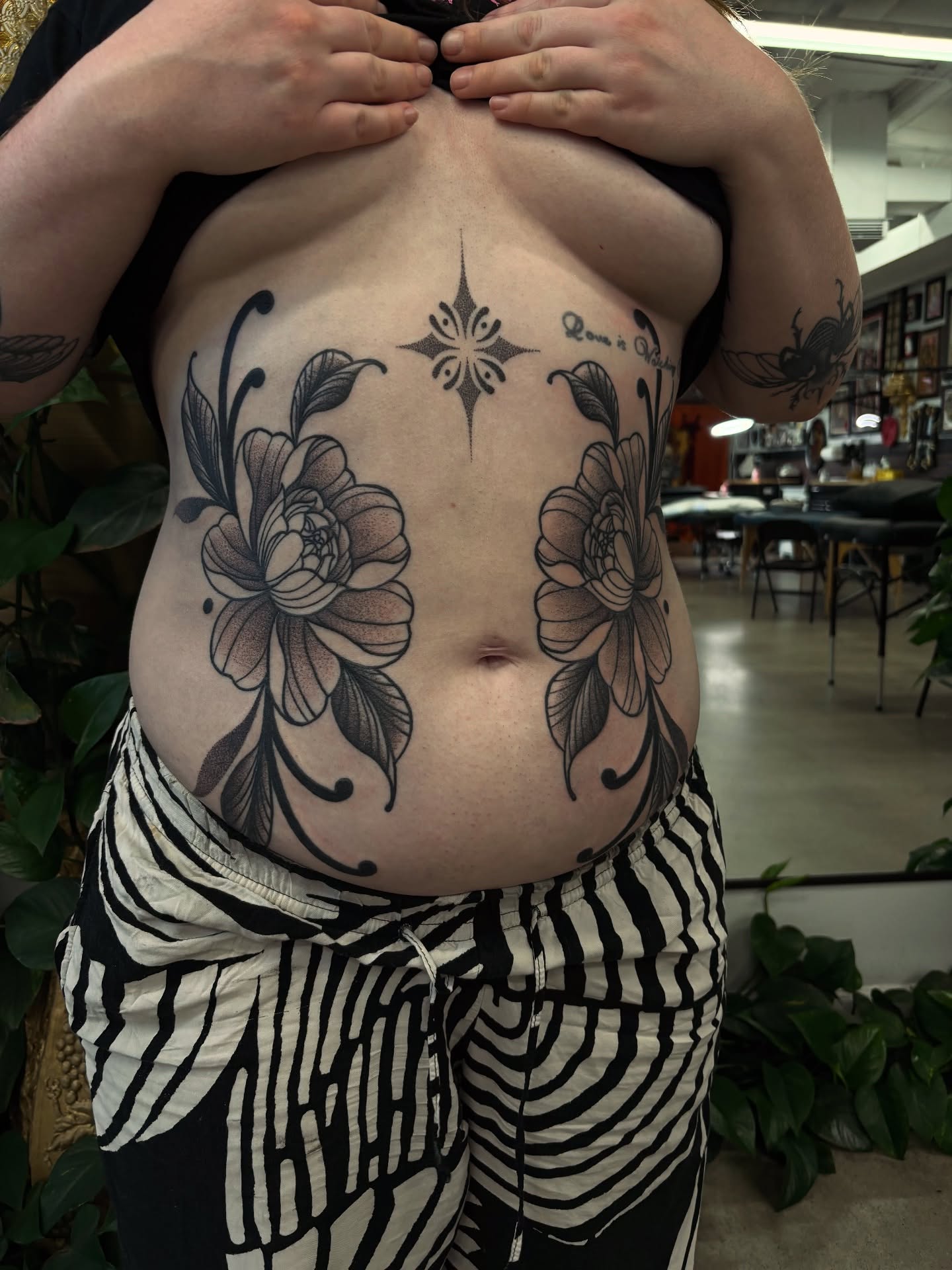Floral design dotwork tattoo on the torso by Kolbi Alexis