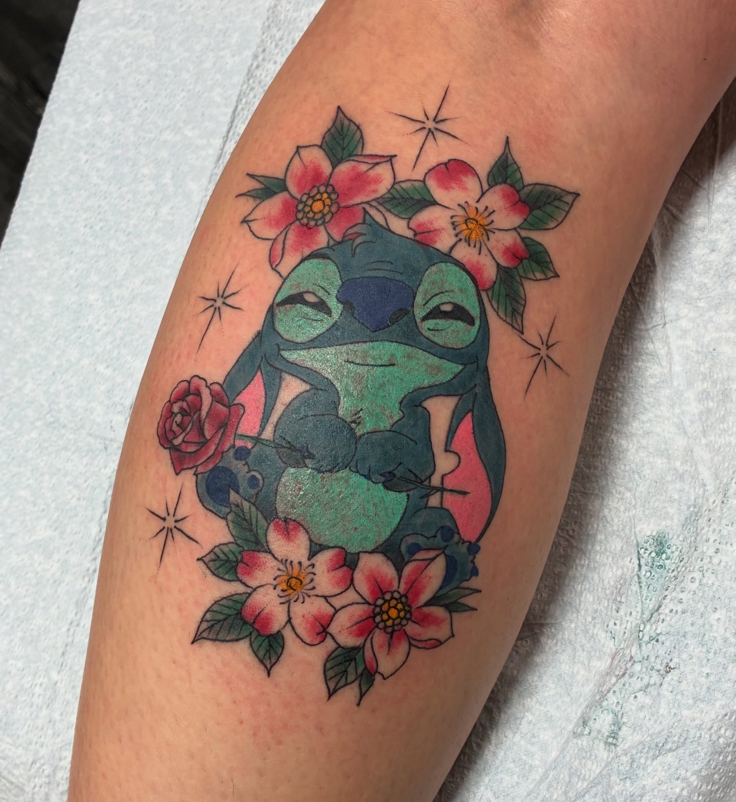 Stitch with flowers new school tattoo on the forearm by Kennedy Cole