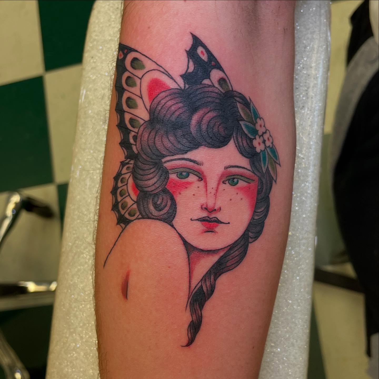 Woman with butterfly American traditional tattoo on the forearm by Dayton Tattoo Artist, Miamisburg, Ohio