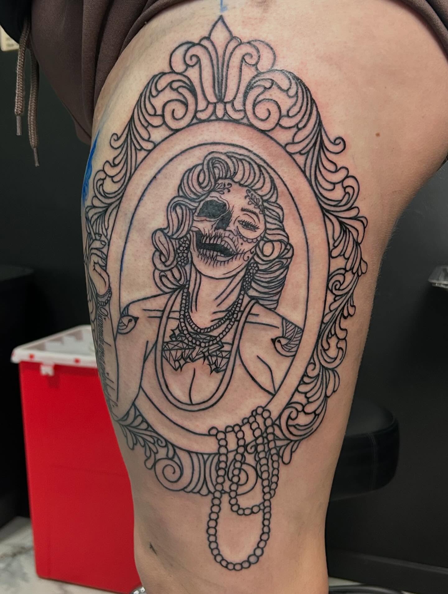Skull in ornate frame realism tattoo on the thigh by Kenadee
