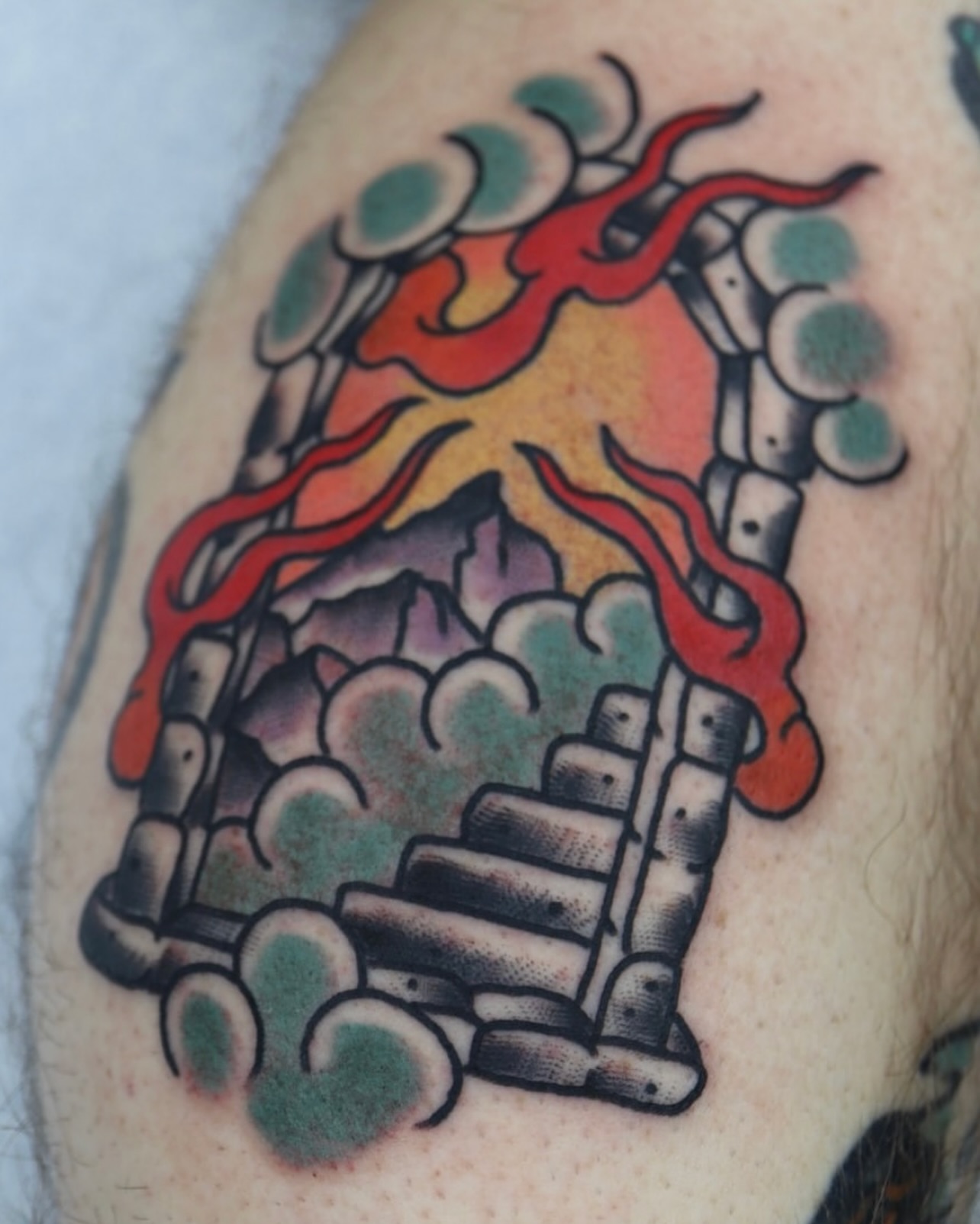 Volcano eruption American traditional tattoo on the upper arm by Stephen Shaw