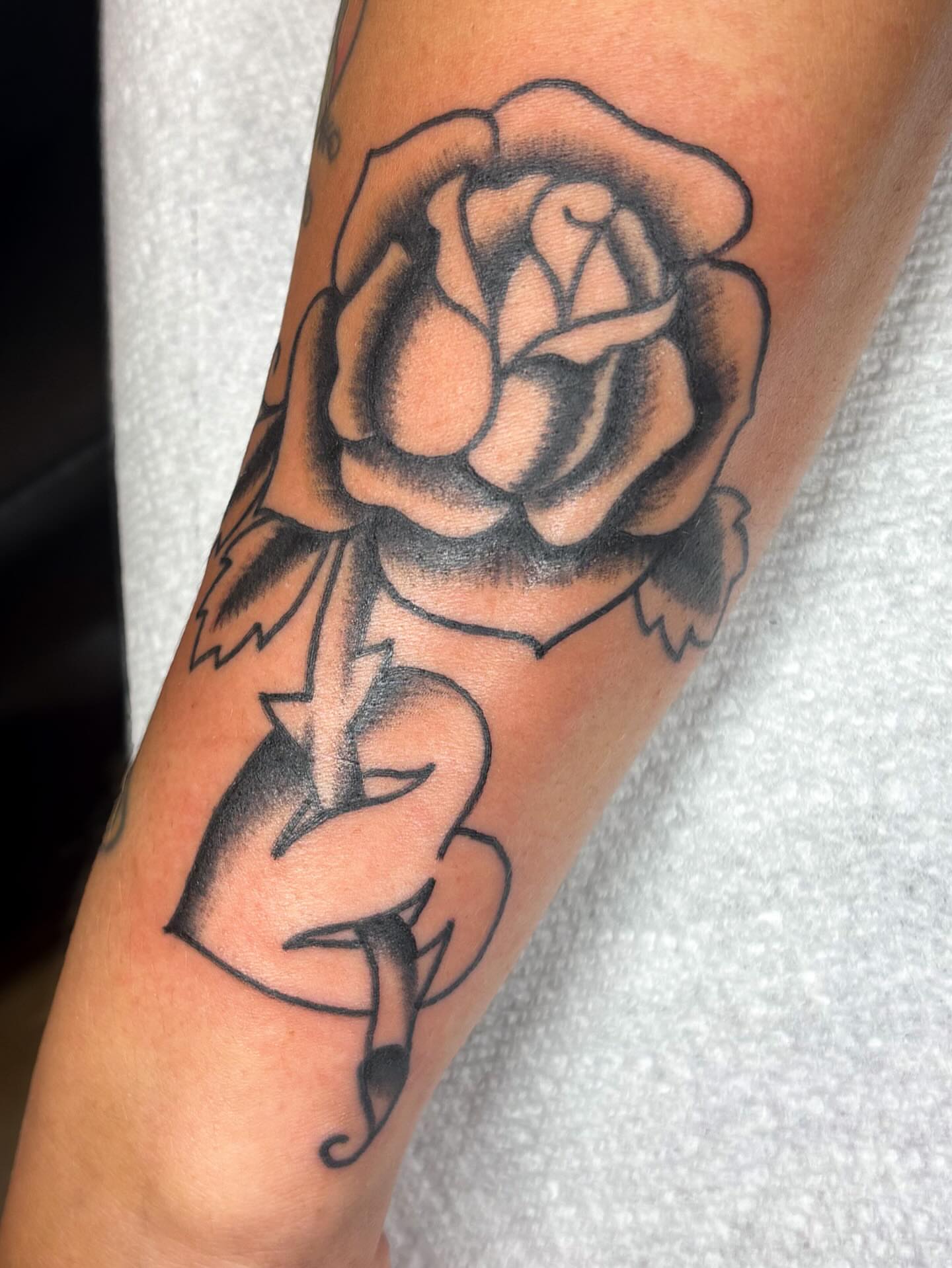 Rose American traditional tattoo on the forearm by Katelyn Spence