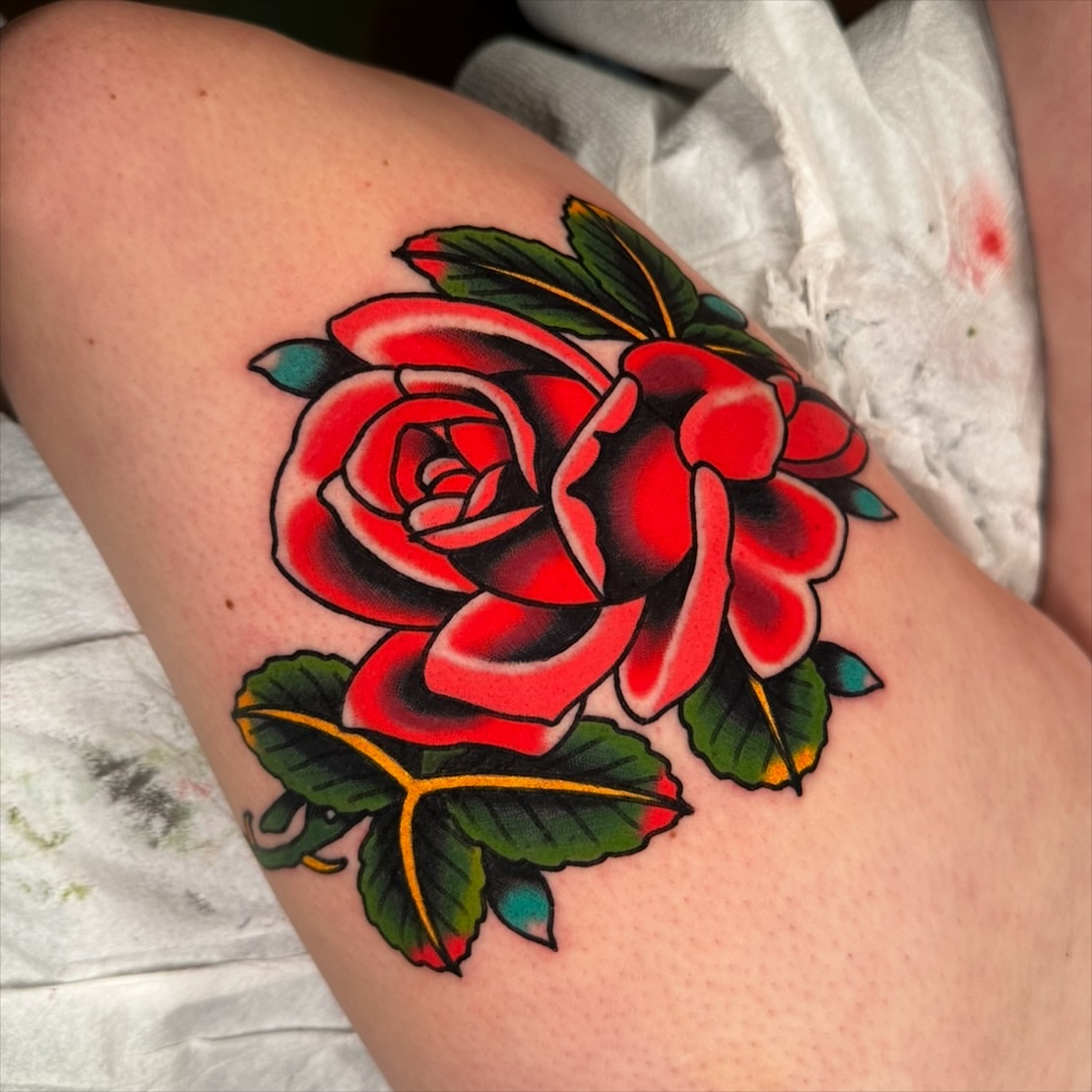 Red rose American traditional tattoo on the thigh by Schyler Ames, Canal Fulton, Ohio