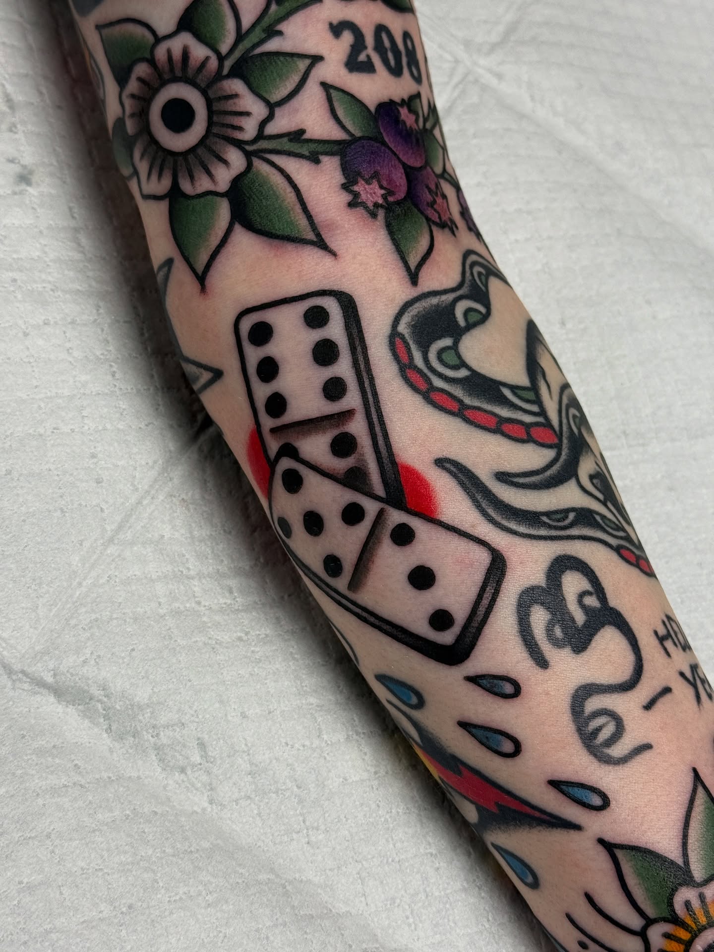 Dominoes and snake American traditional tattoo on the forearm by Jordan Allen