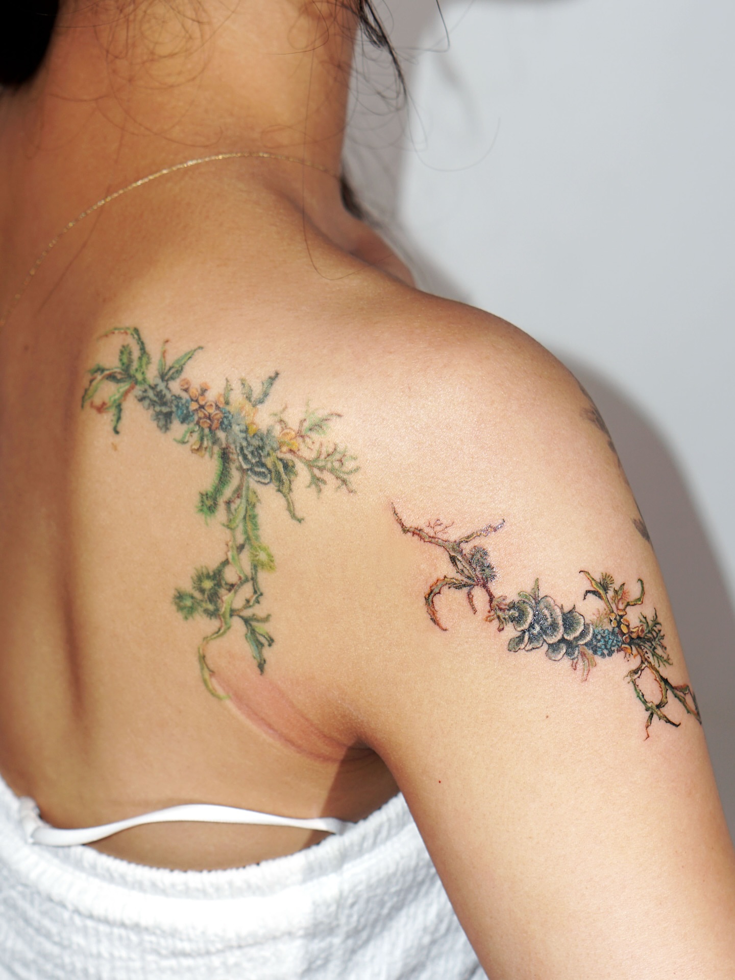 Branch with flowers watercolor tattoo on the shoulder by Isle