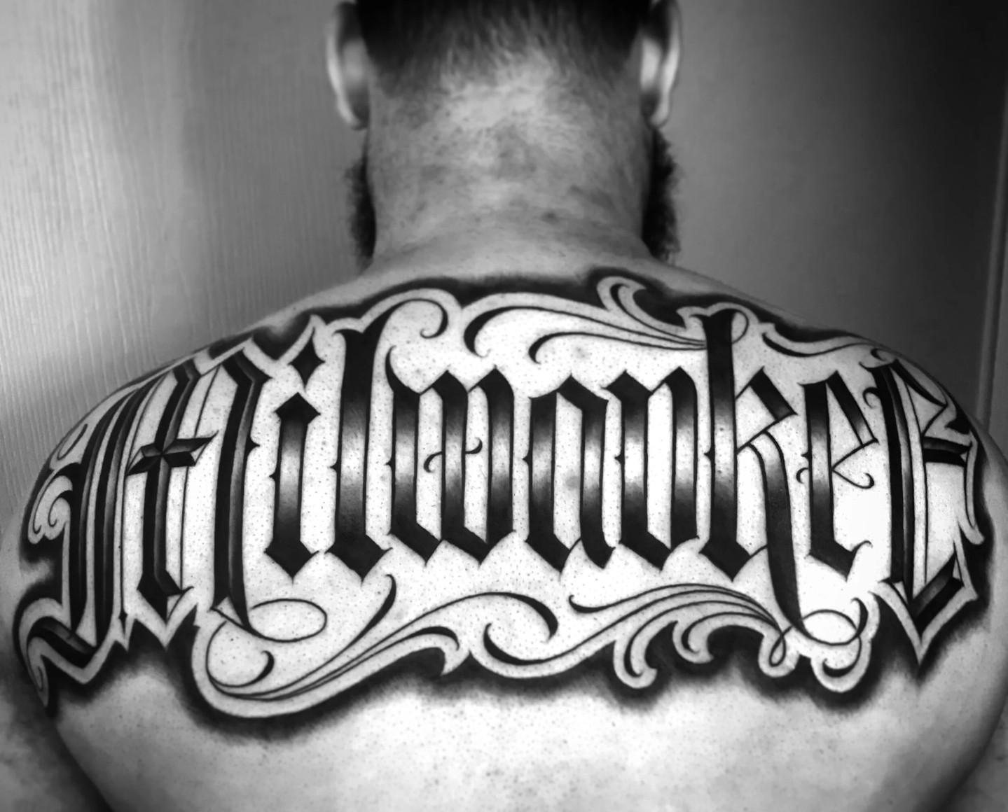 Milwaukee lettering script tattoo on the back by F e A R