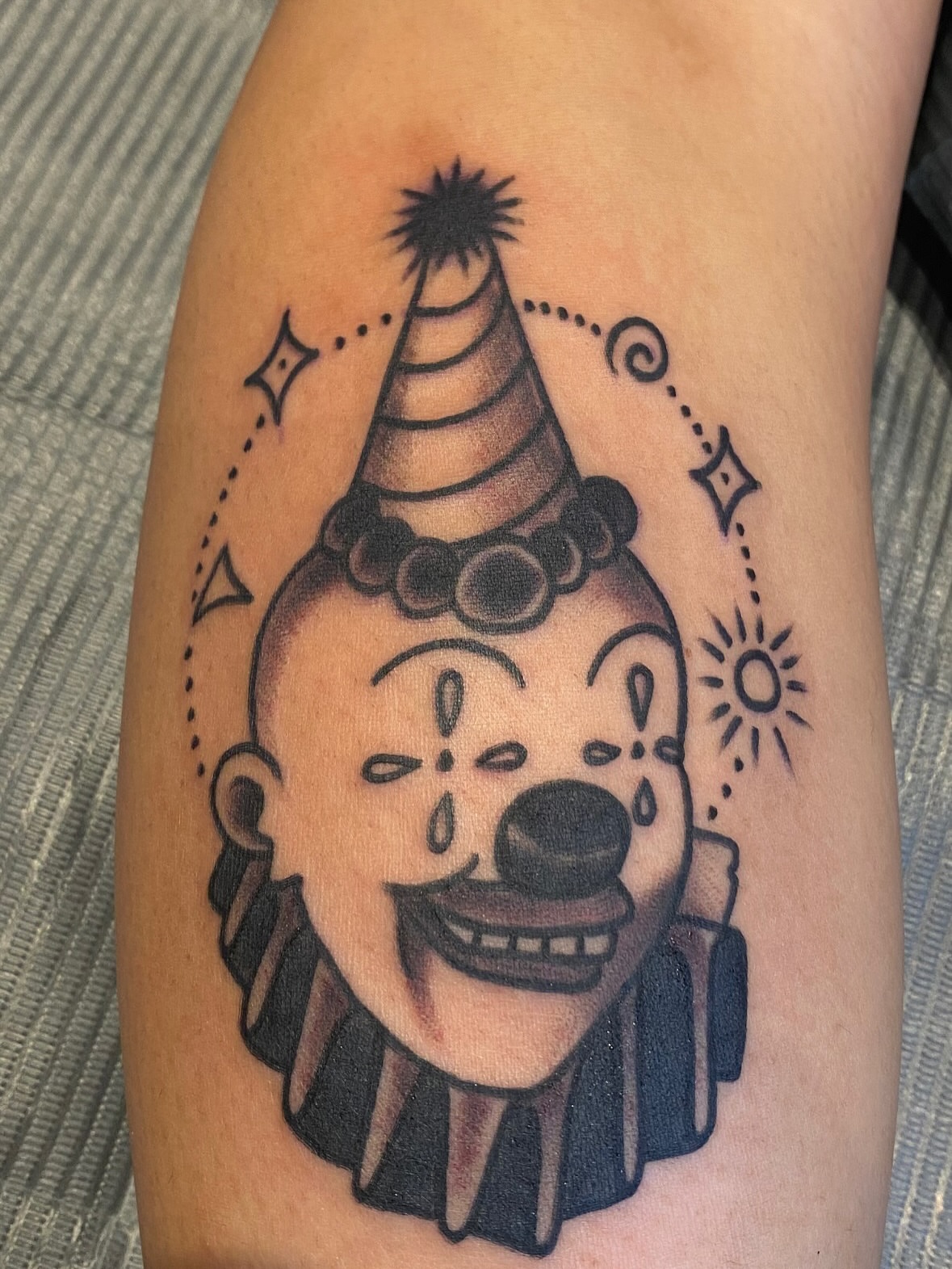 Clown head American traditional tattoo on the forearm by John Black