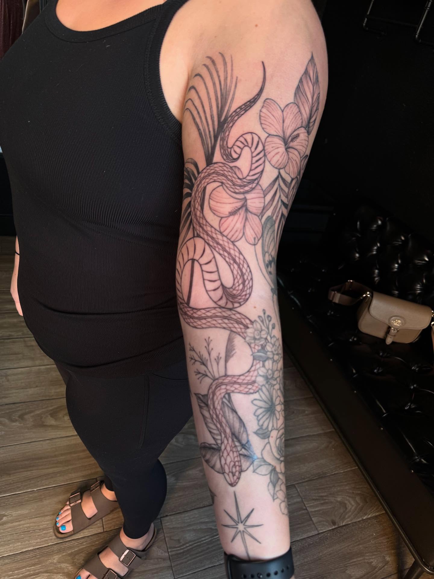 Snake and flowers neo-traditional tattoo on the forearm by Mickey