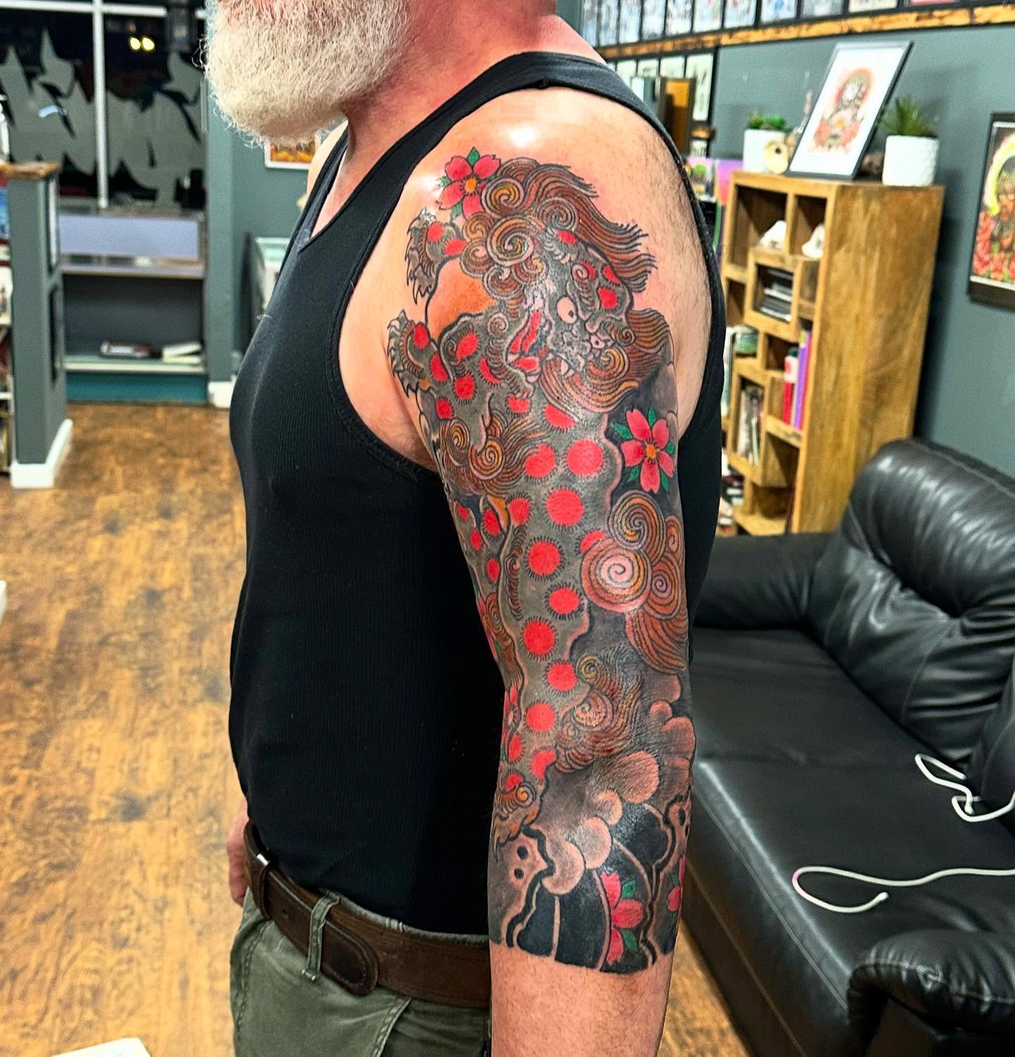 Lion dotwork tattoo on the upper arm by Jackie