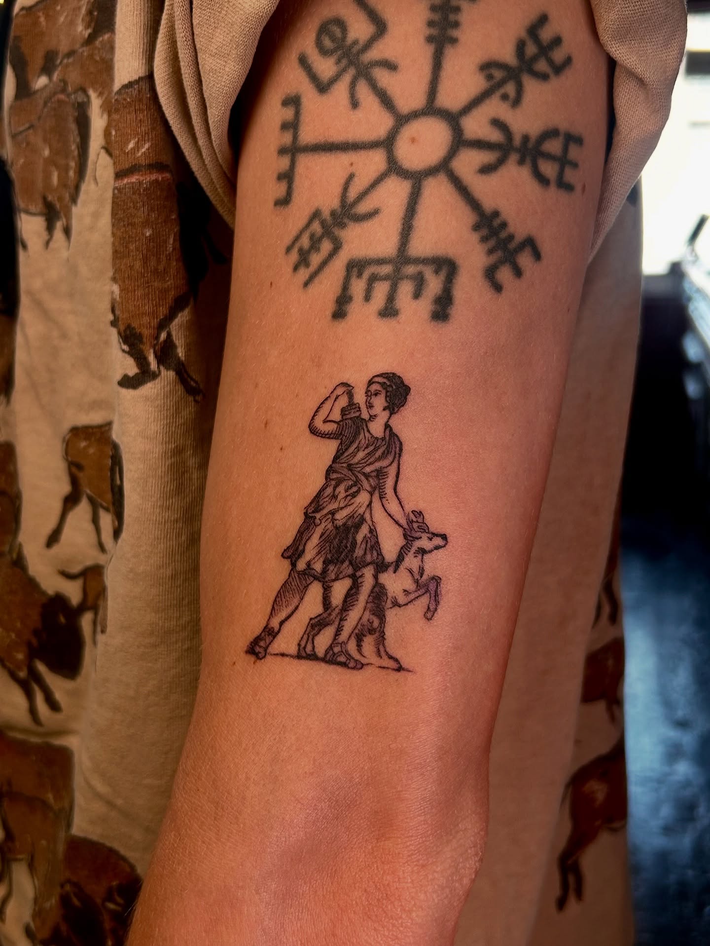 Woman with dog black and grey tattoo on the forearm by King By Trade 👑