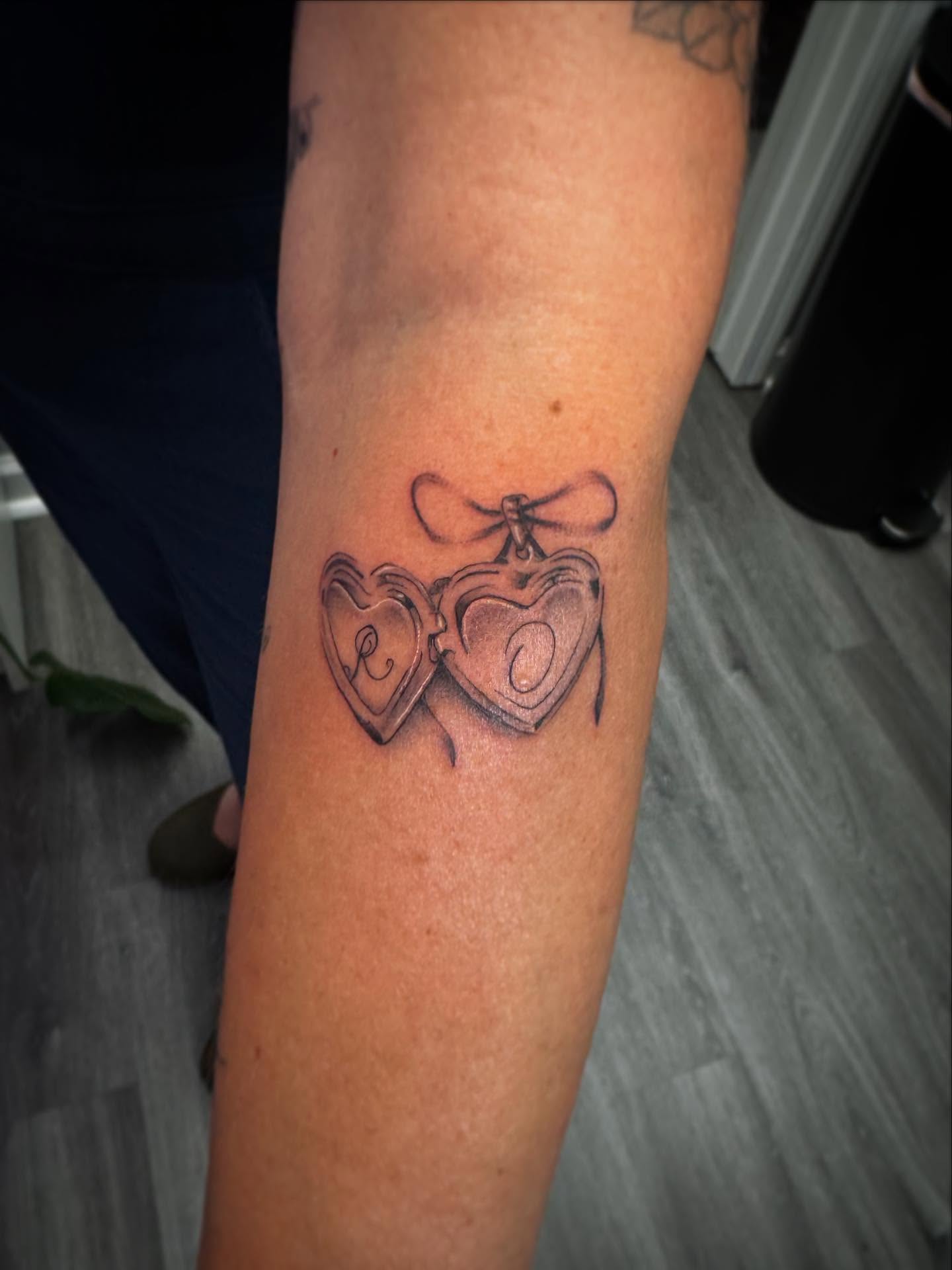 Heart-shaped locket black and grey tattoo on the forearm by Bethany Foeller
