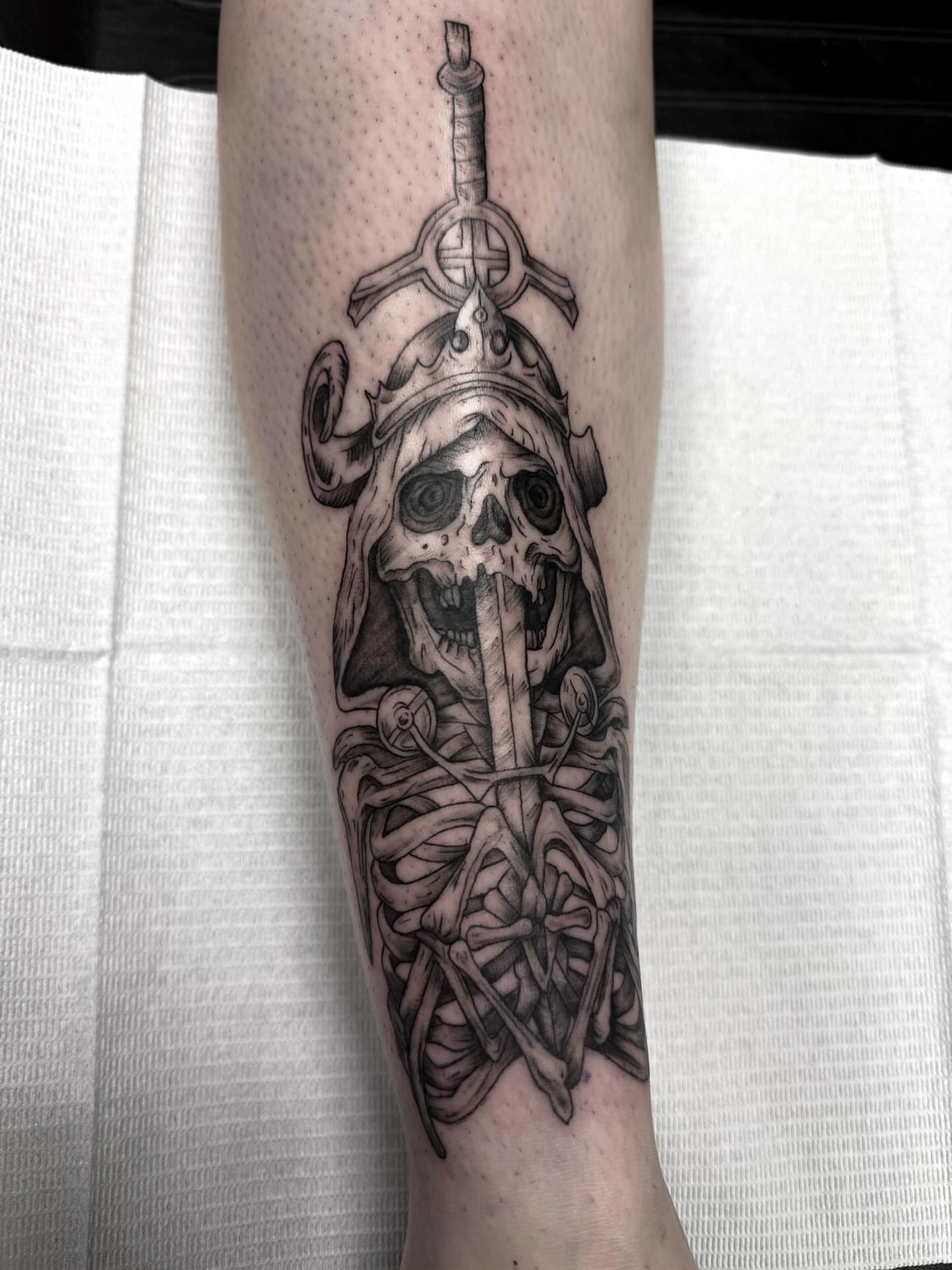 Skull with sword realism tattoo on the forearm by Rachel