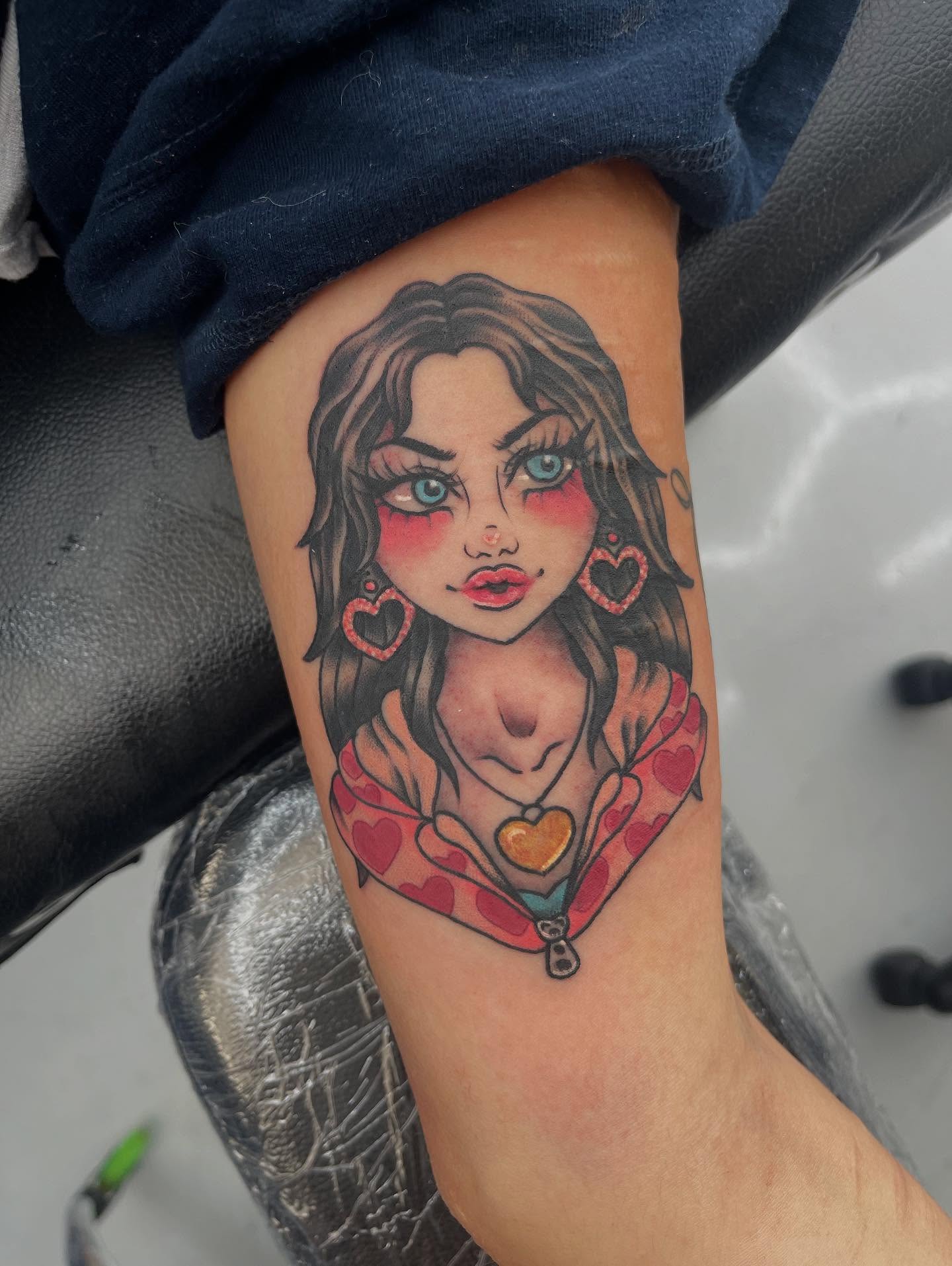 Doll-like girl illustrative tattoo on the forearm by Autumn Fulford