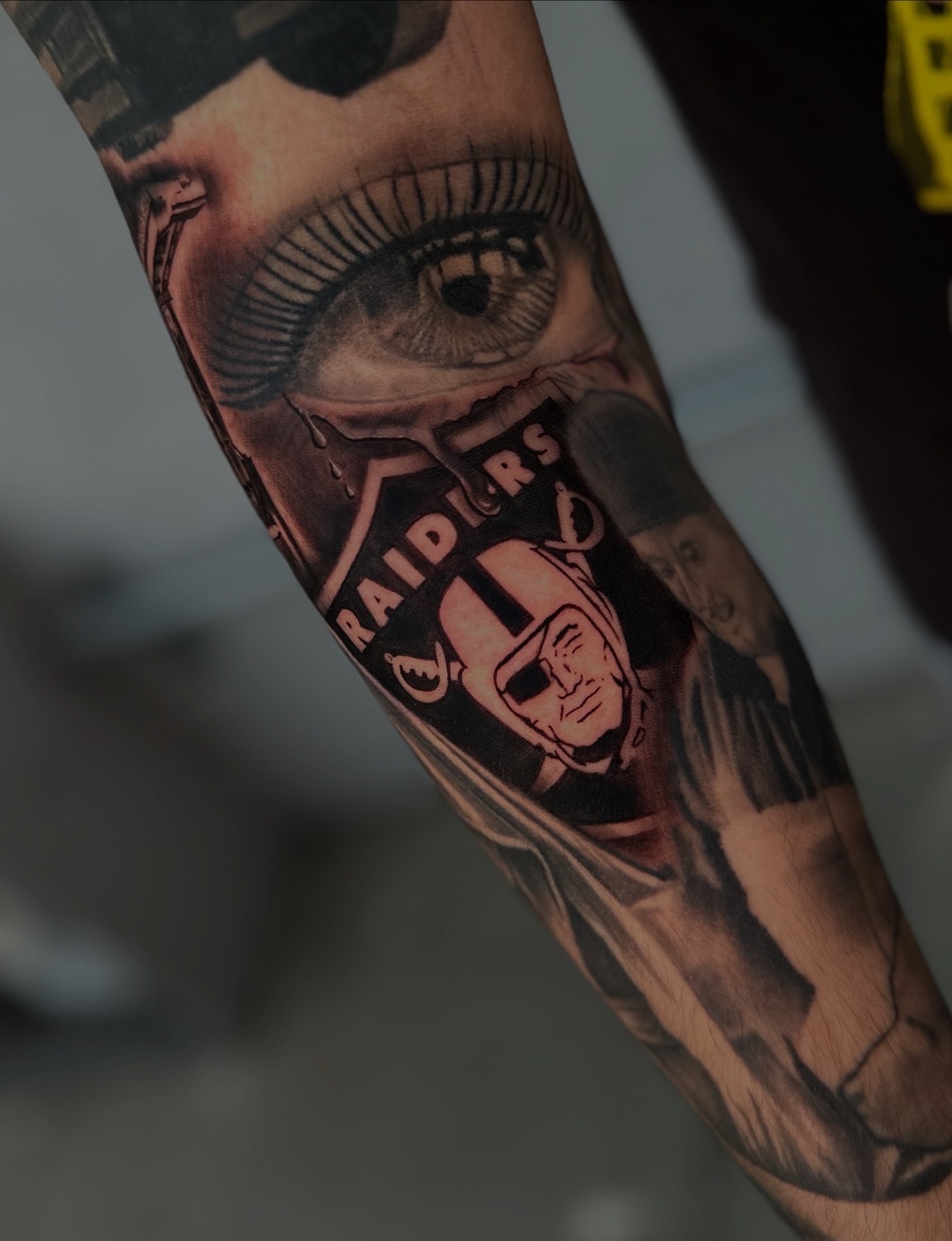 Eye and football player realism tattoo on the forearm by Mando