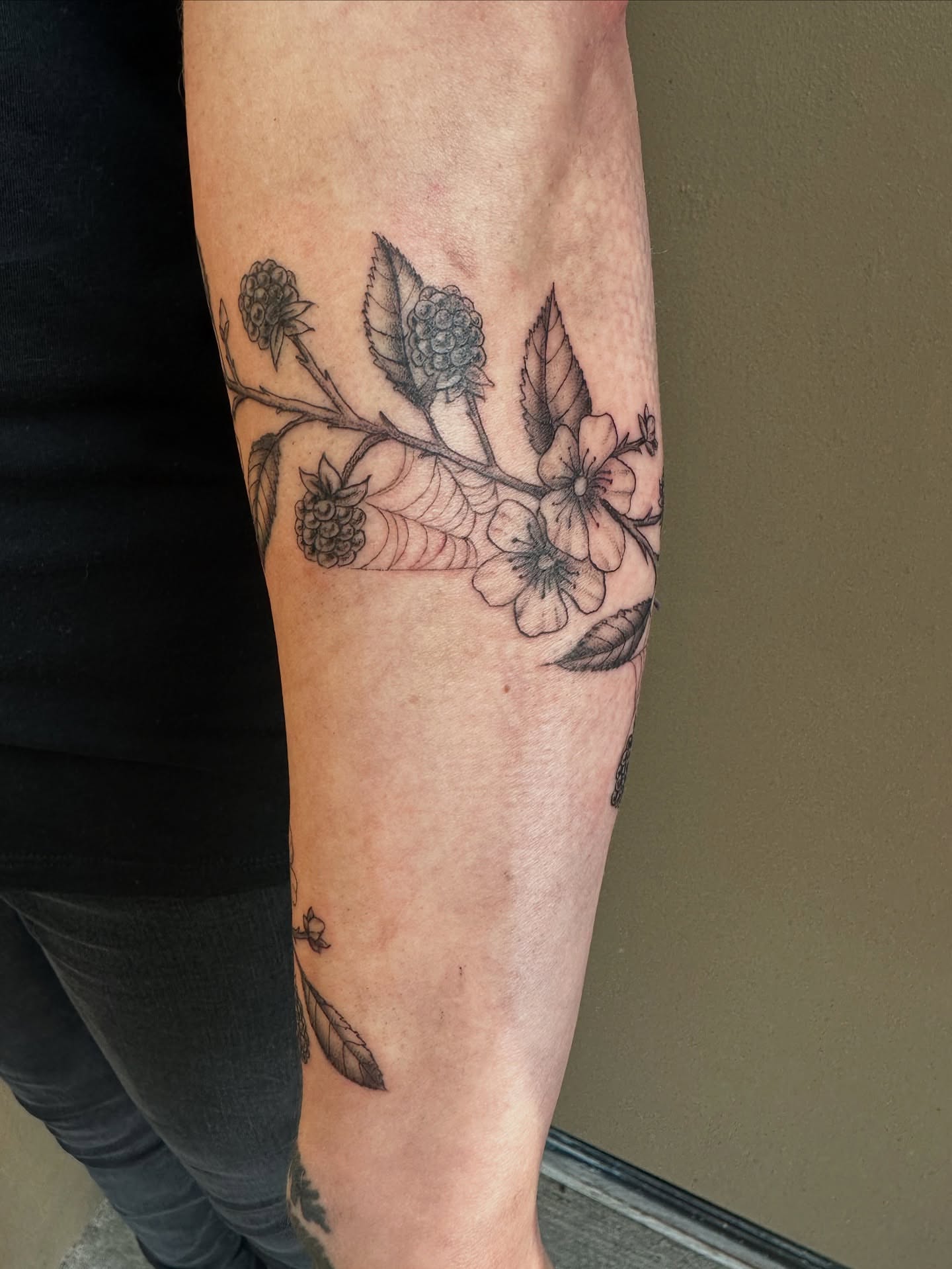 Flower branch black and grey tattoo on the forearm by Lauren DeLizza