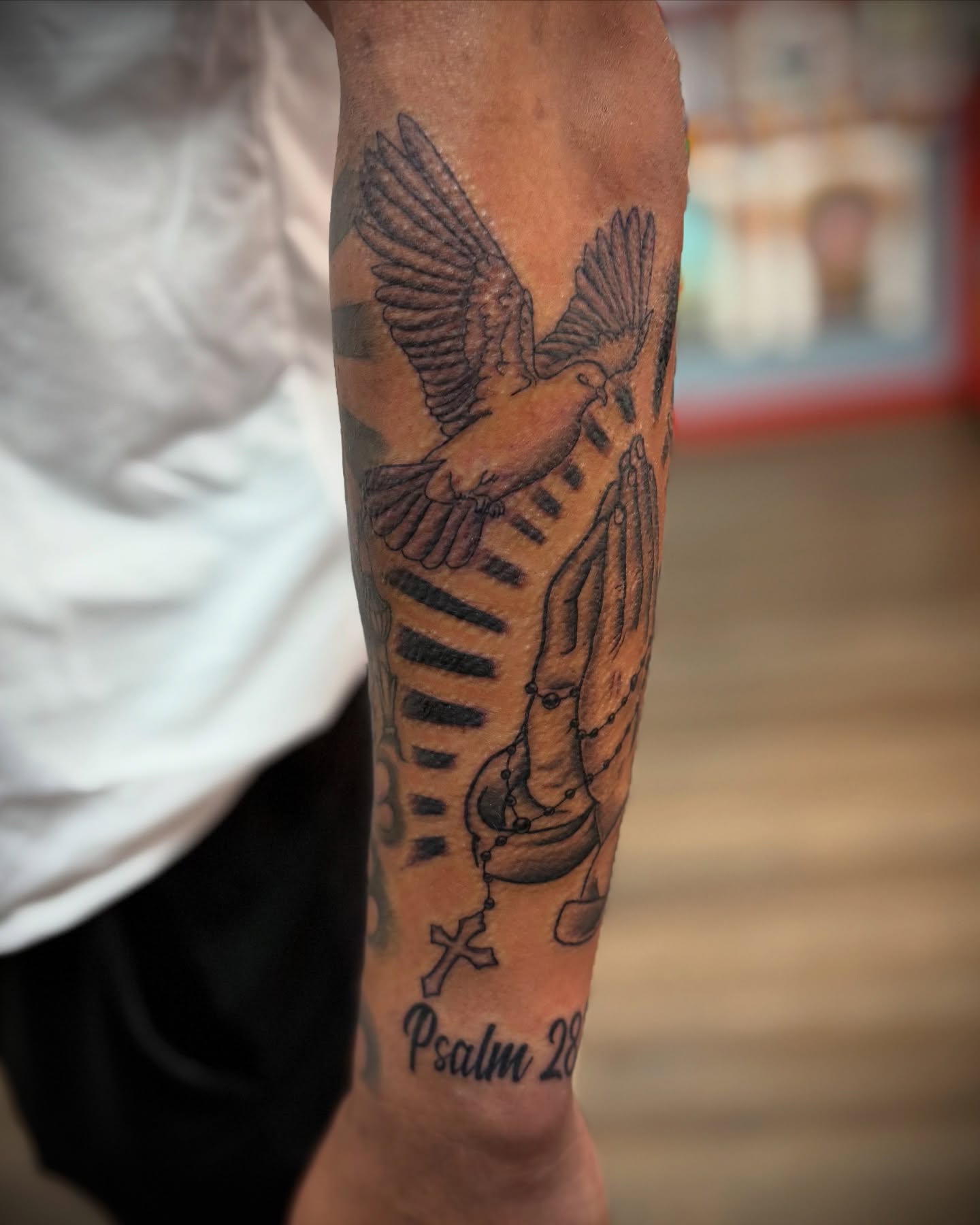 Praying hands with dove black and grey tattoo on the forearm by Justin Bianchini - New Orleans Tattoo Artist