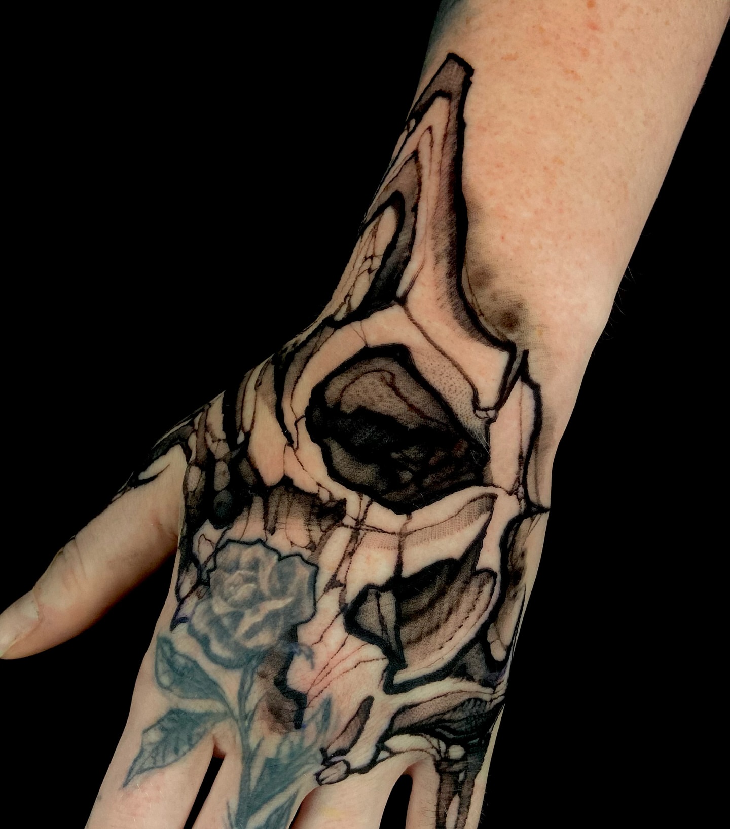 Skull and rose realism tattoo on the hand by Nathan