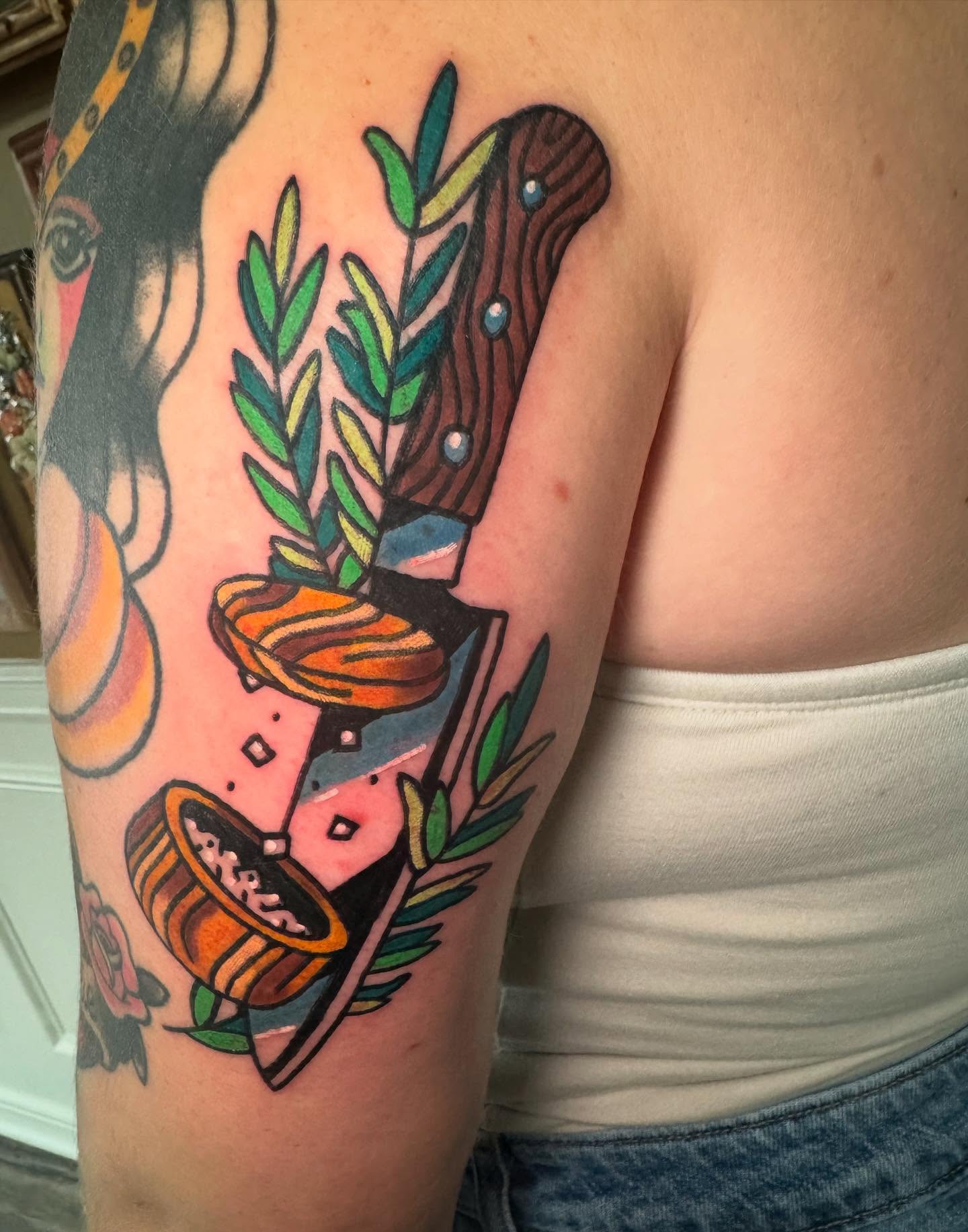 Knife and leaves American traditional tattoo on the upper arm by Perrey