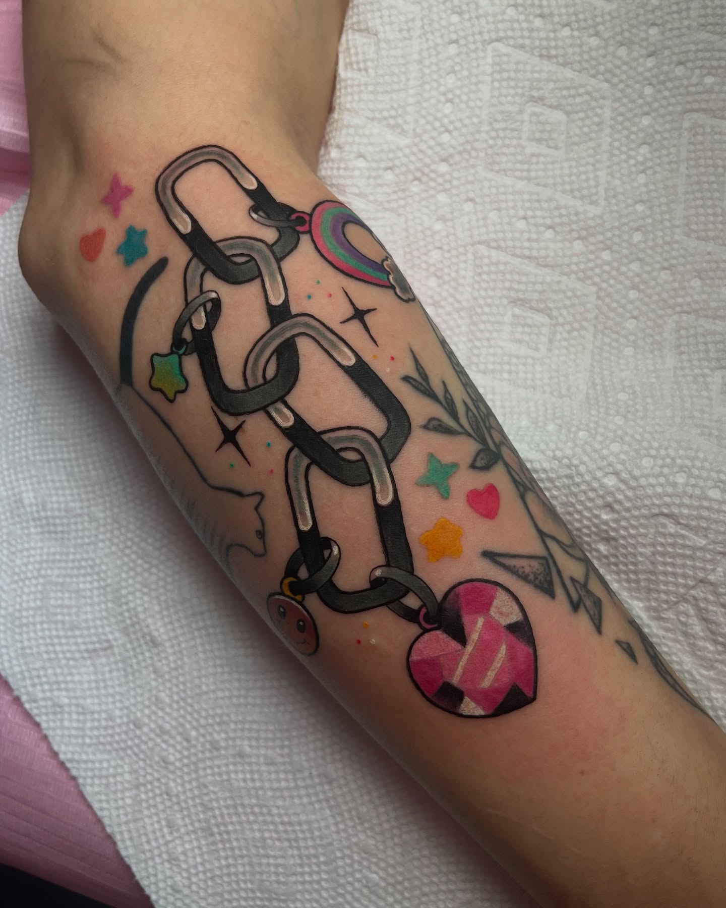 Chain with charms new school tattoo on the forearm by Chloe Marie
