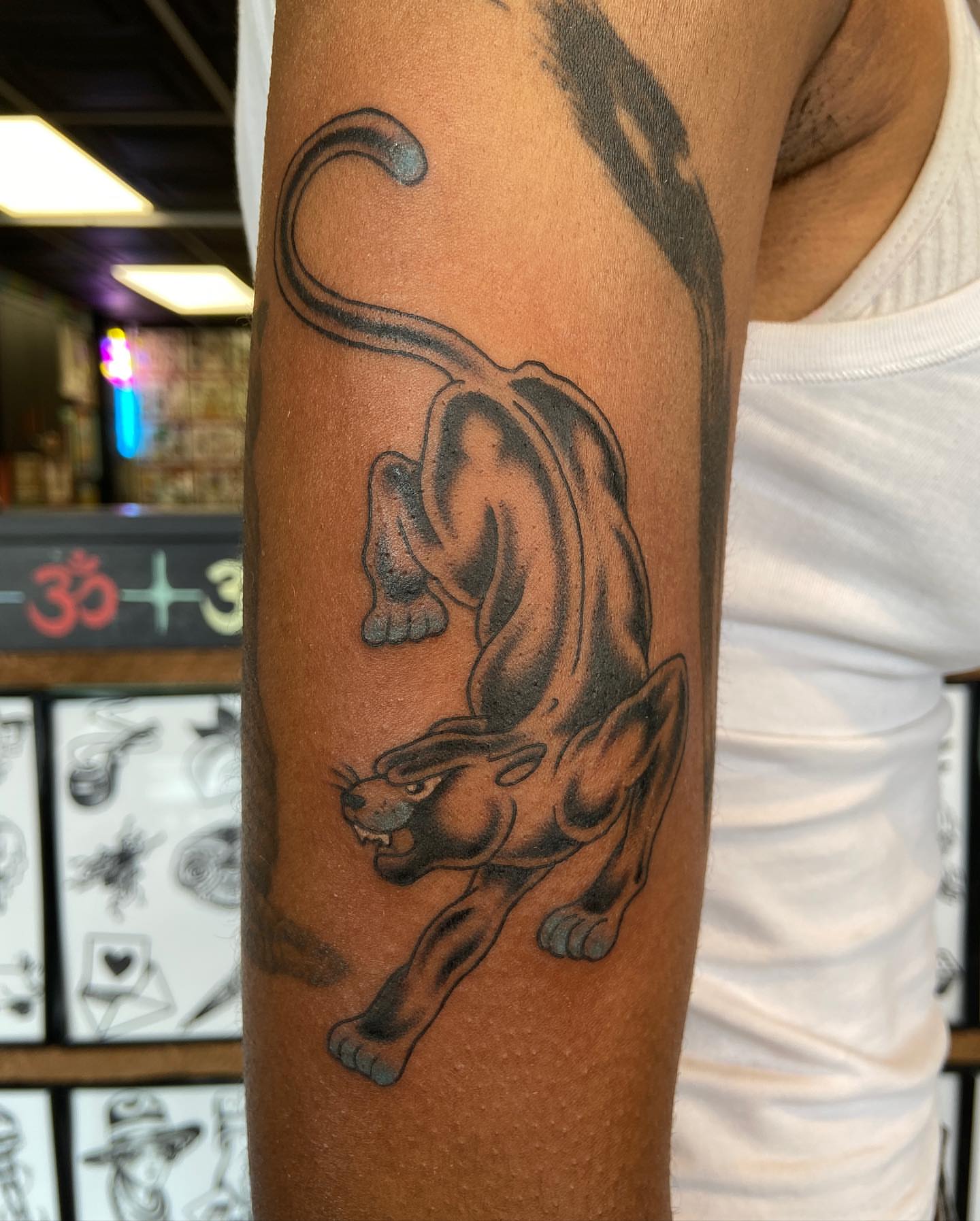 Panther black and grey tattoo on the forearm by Lucía