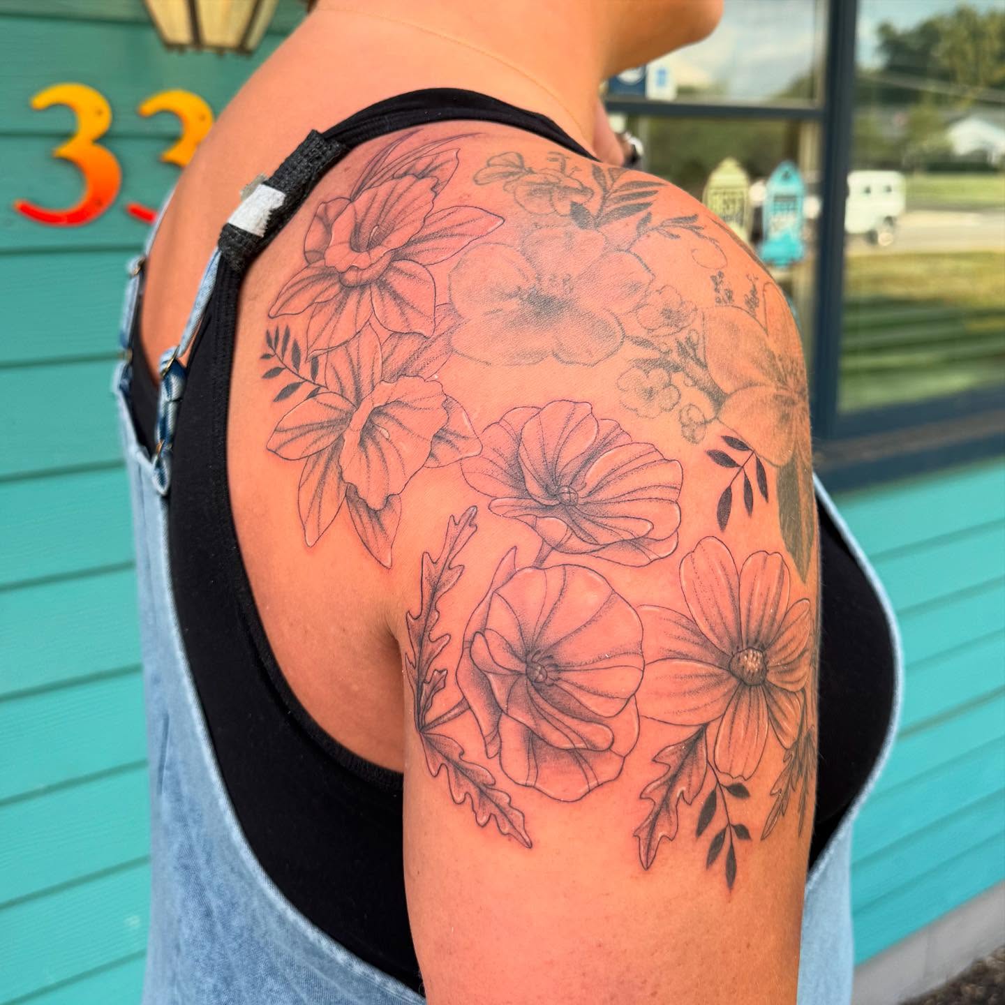 Floral bouquet black and grey tattoo on the shoulder by Leslea Hipp