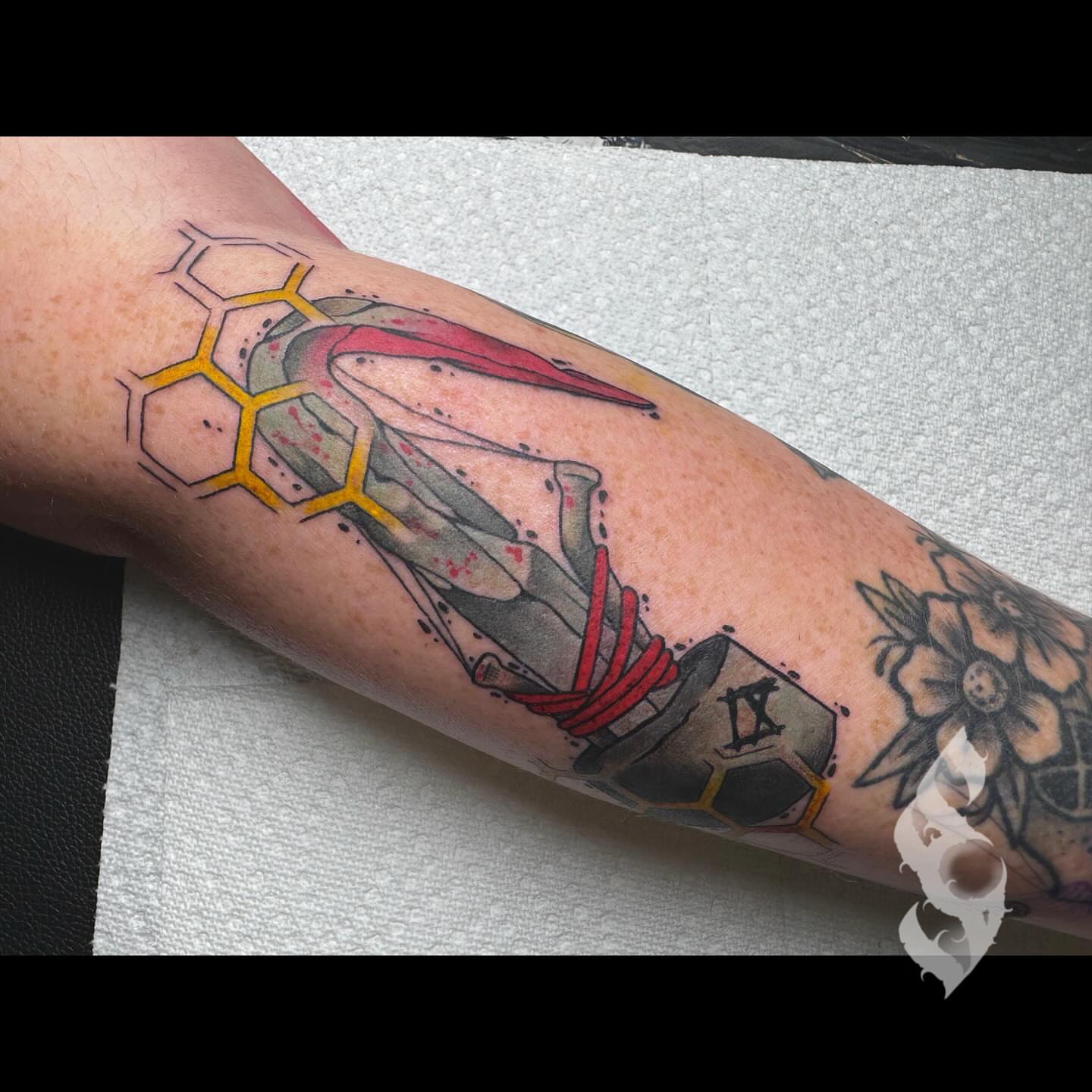 Gun and honeycomb geometric tattoo on the forearm by Amanda Stampfly