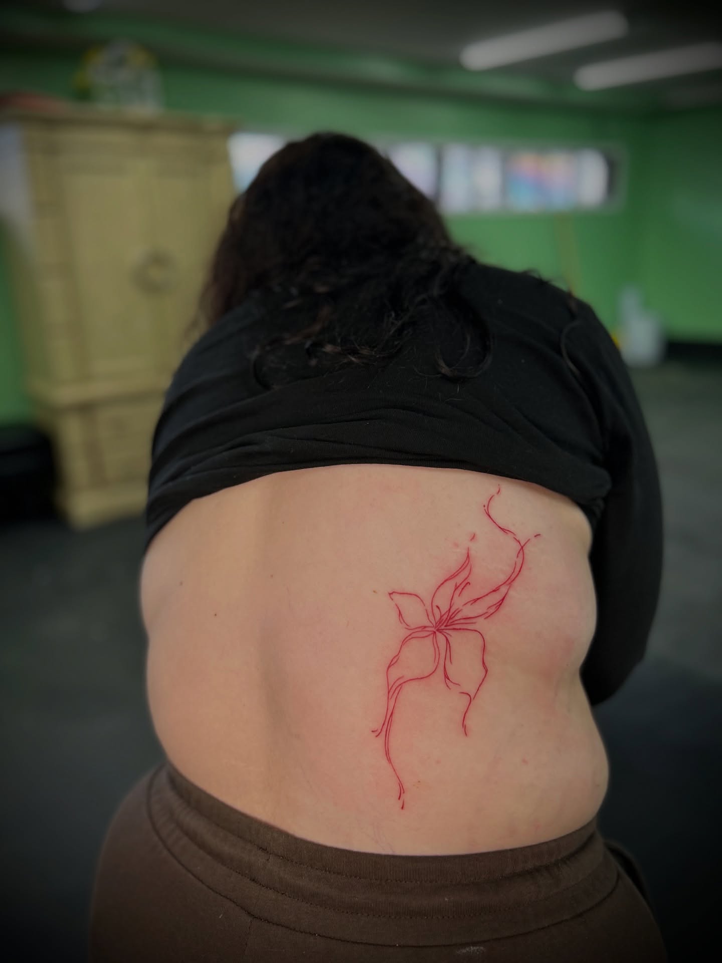 Flower fine line tattoo on the torso by Kiersten Tickle