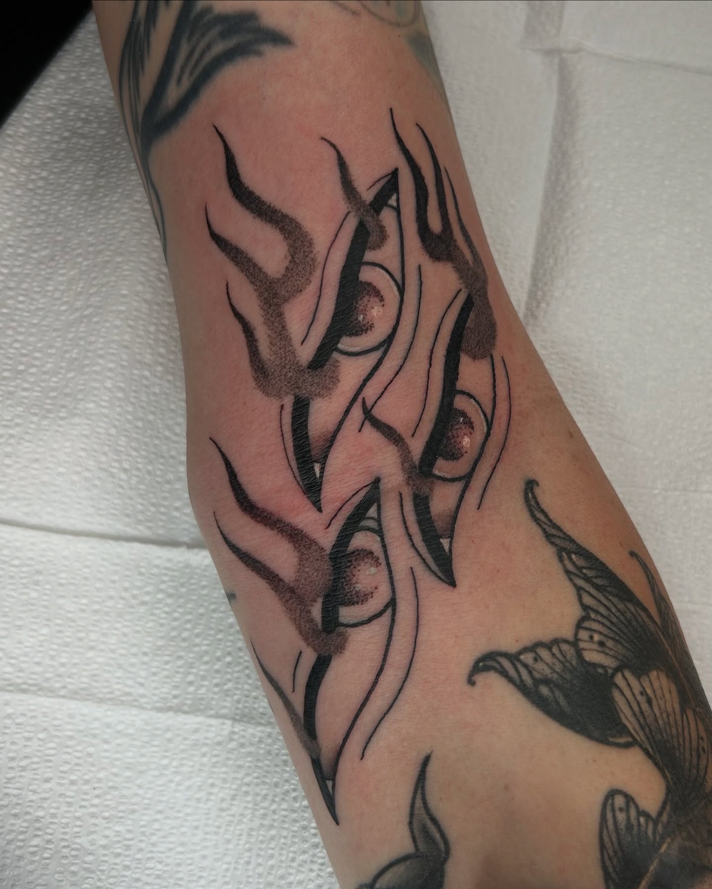 Flames tribal tattoo on the forearm by Noah Crow