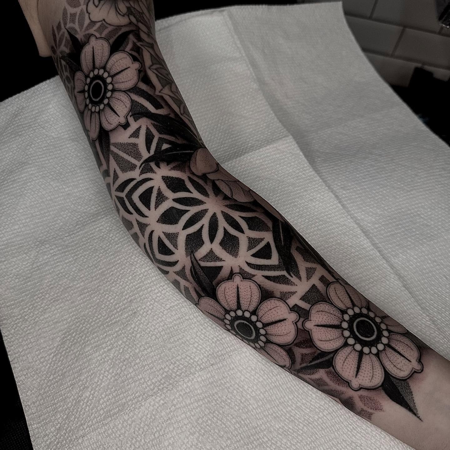 Floral pattern black and grey tattoo on the forearm by Kevin Johnson