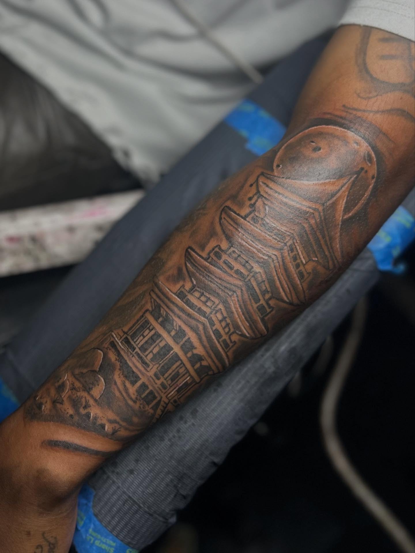 Building black and grey tattoo on the forearm by Rell Washington, Marlow Heights, Maryland