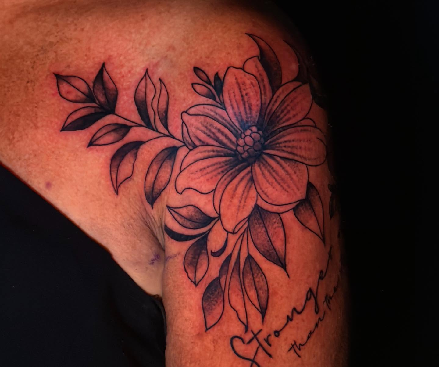 Flower black and grey tattoo on the upper arm by Troy Butner