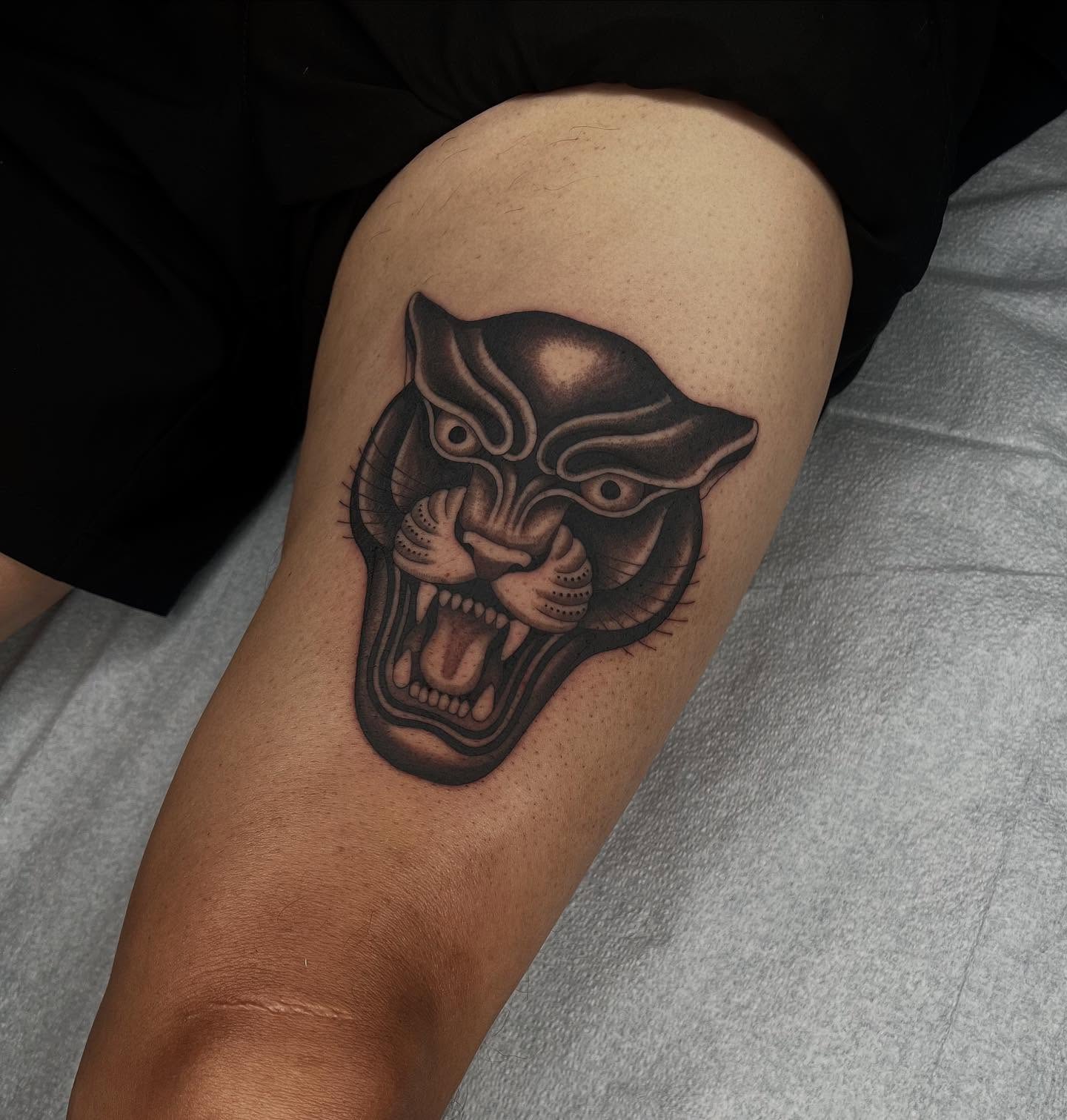 Panther head black and grey tattoo on the thigh by linahsiaotattoo
