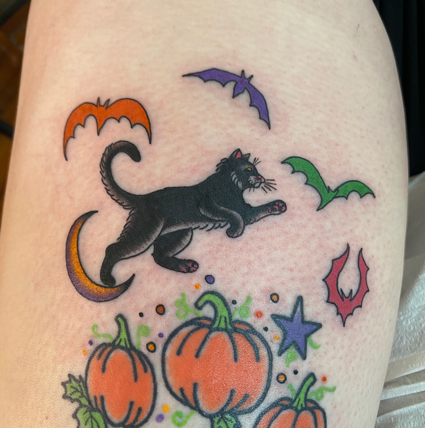 Black cat and Halloween motifs American traditional tattoo on the thigh by atomlenhart, Lancaster, Pennsylvania