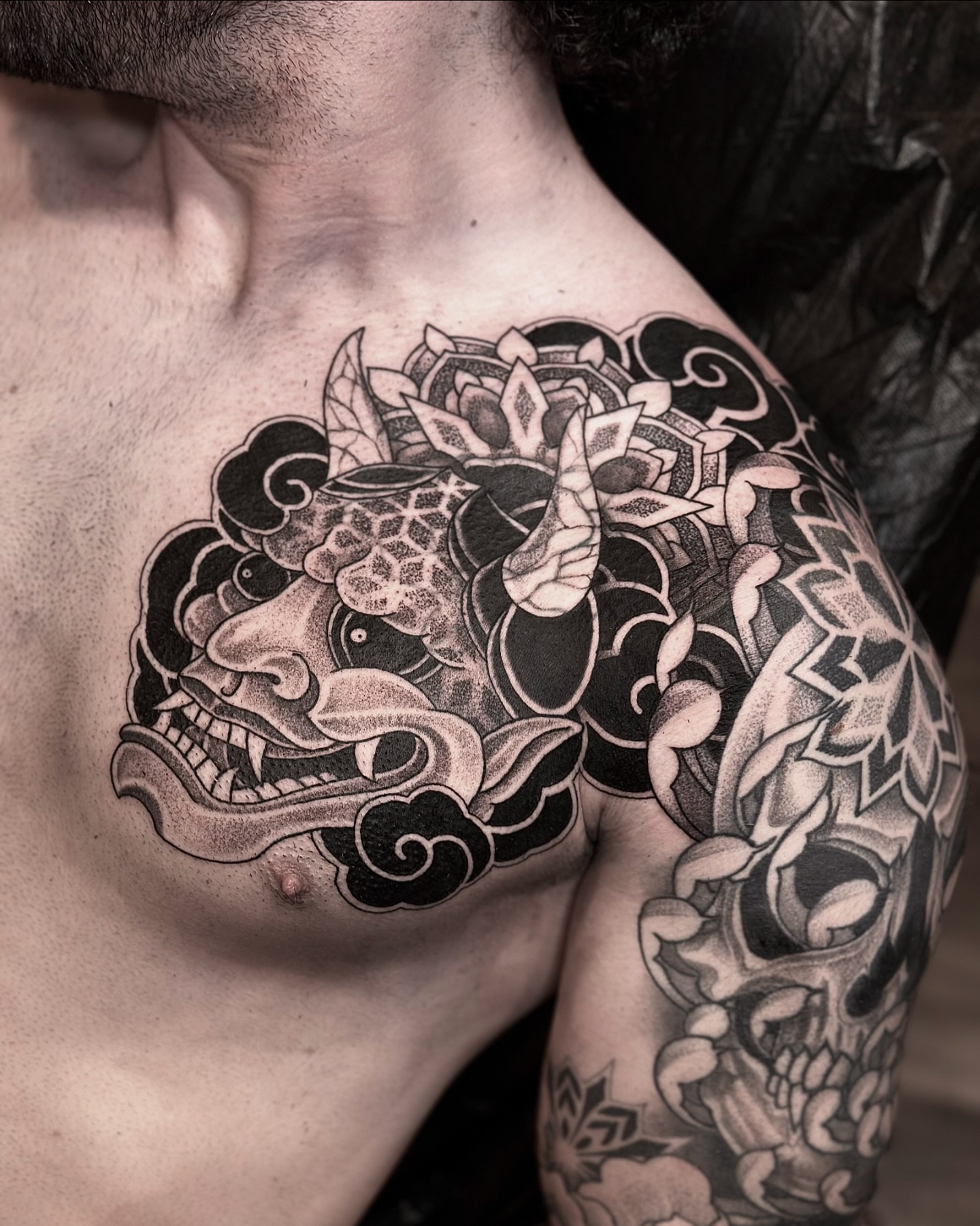 Japanese mask and lotus dotwork tattoo on the chest by Nick Fierro