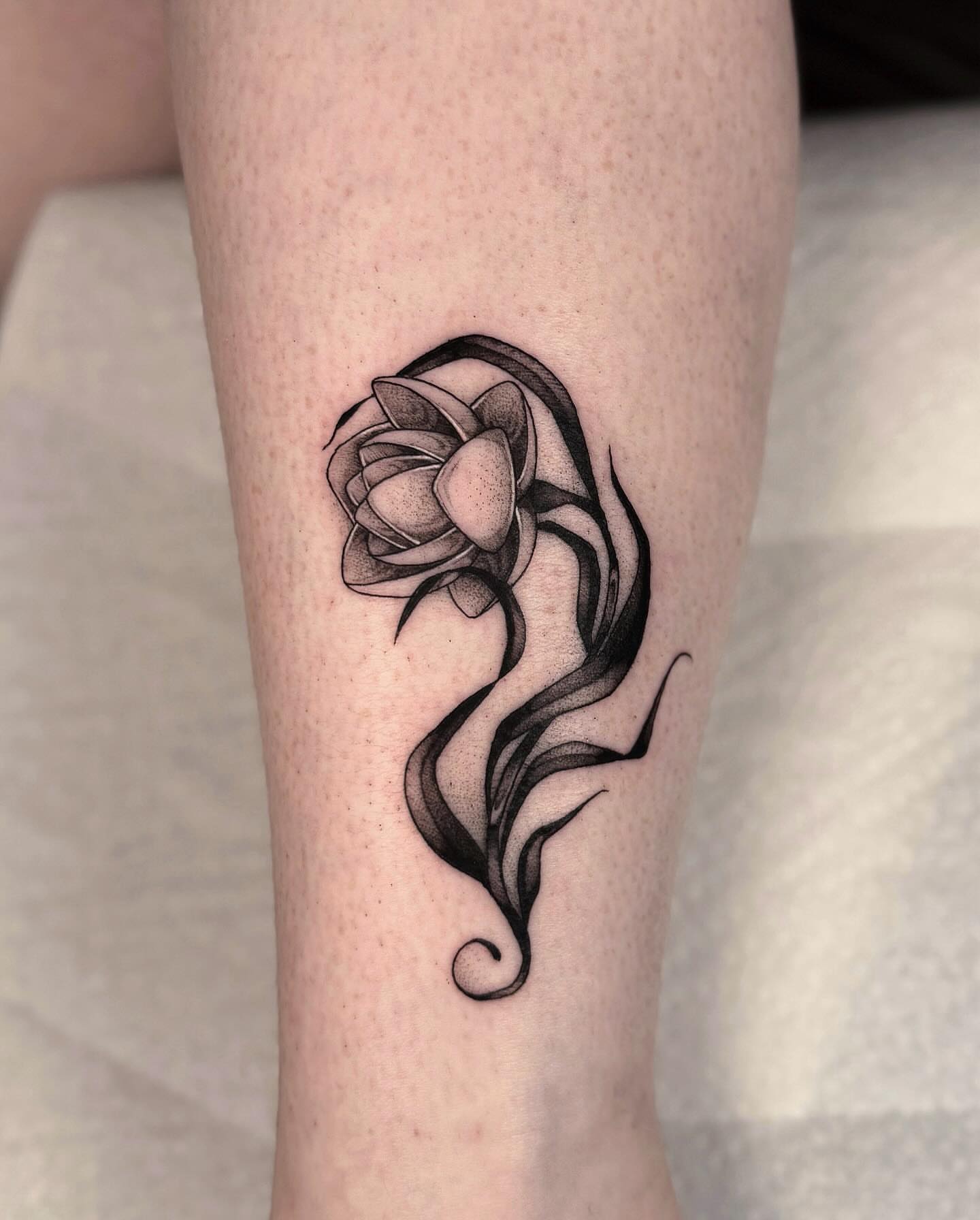 Lotus flower black and grey tattoo on the forearm by jada