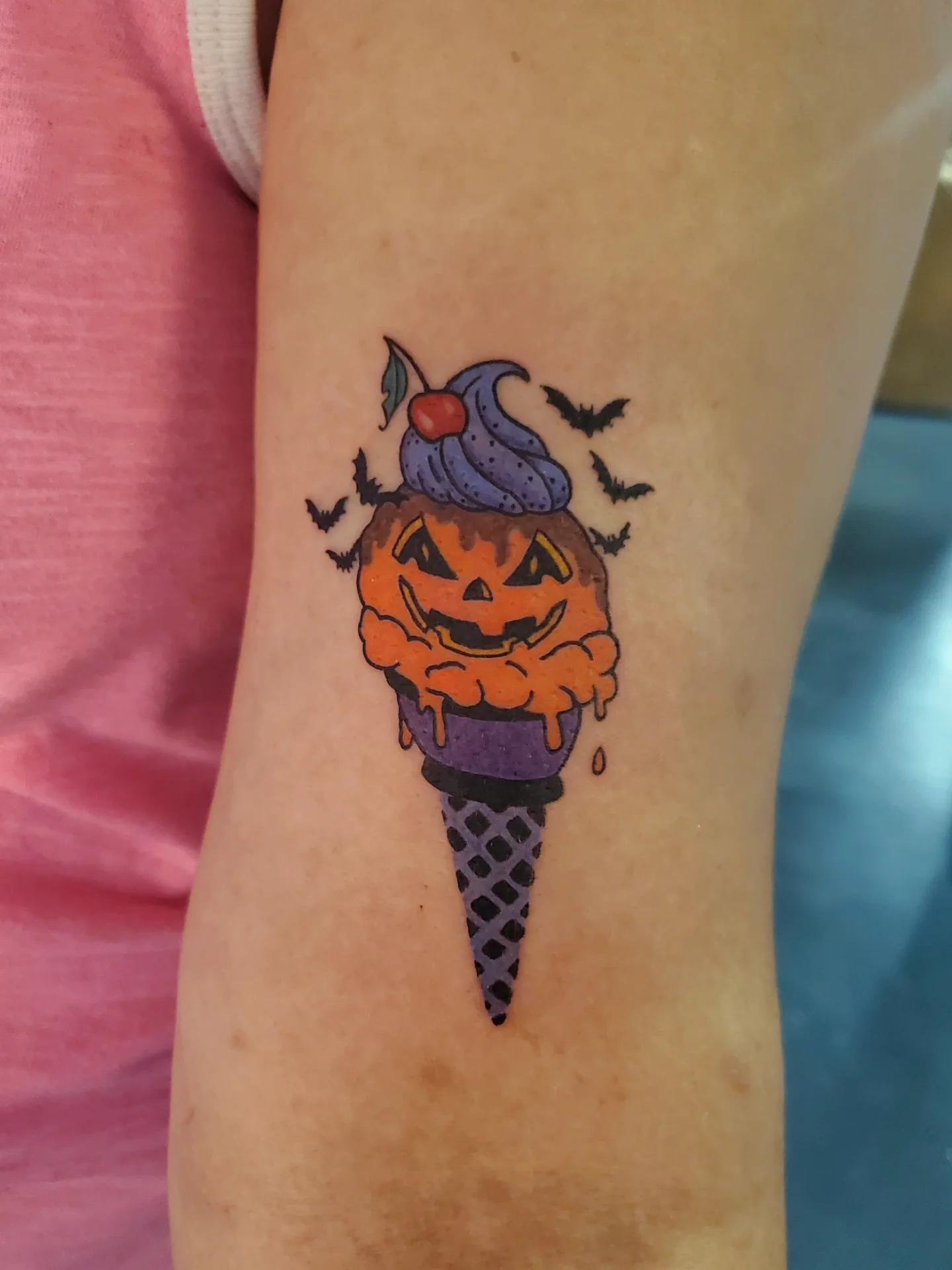 Ice cream cone with jack-o'-lantern new school tattoo on the forearm by Shailey Pasquale