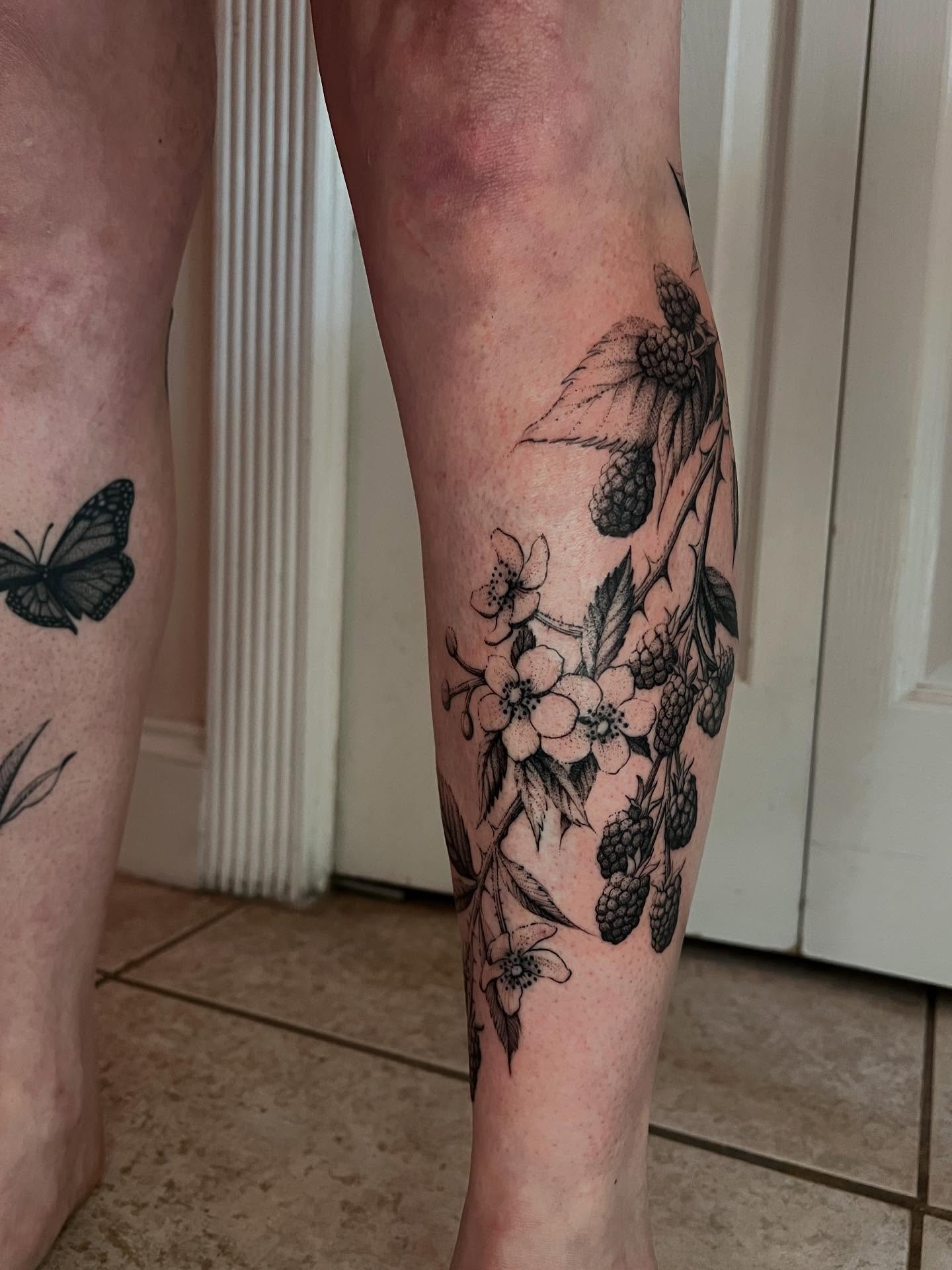 Flower and berries black and grey tattoo on the calf by Natasha