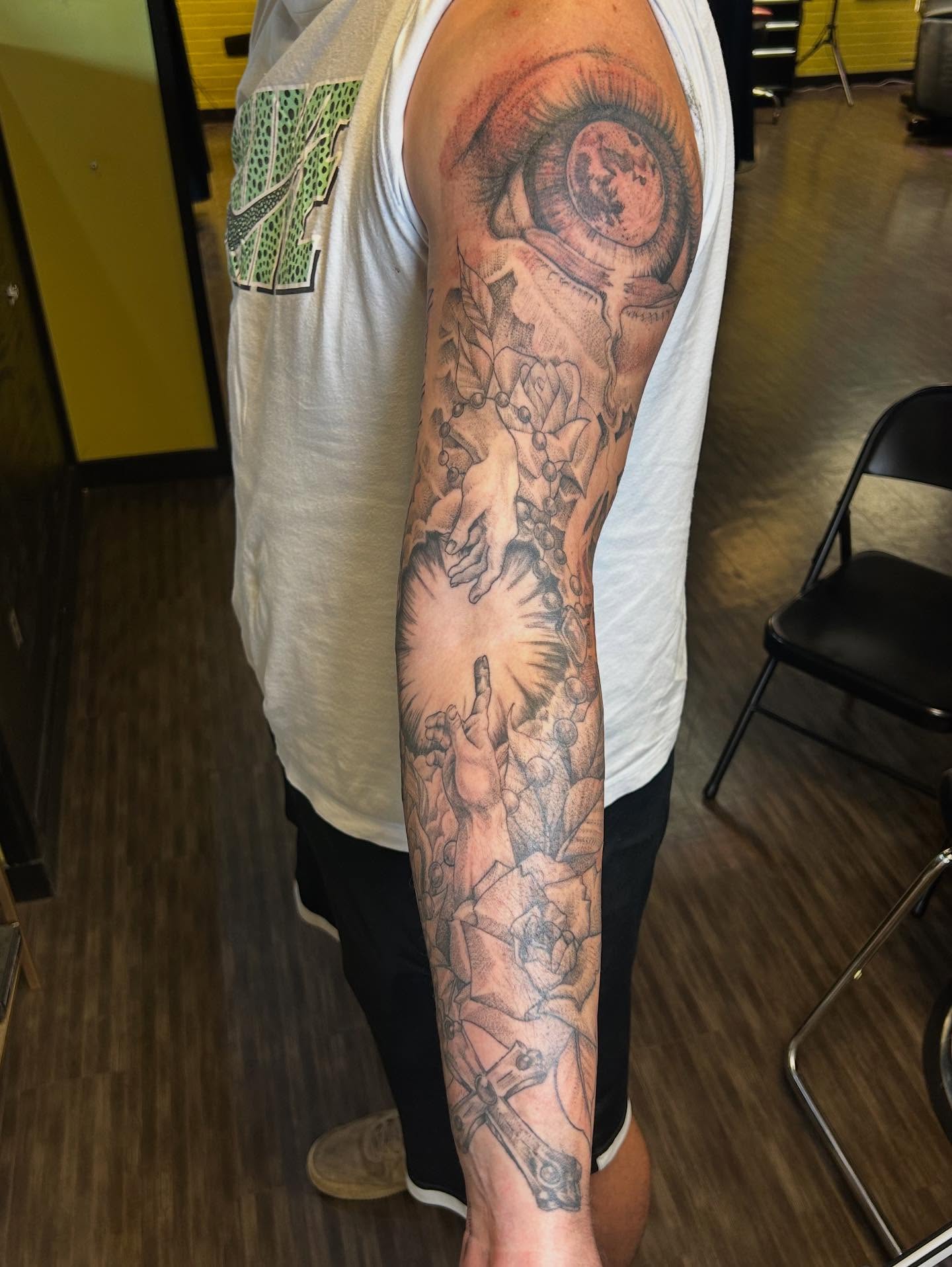 Eye and floral realism tattoo on the forearm by Evan