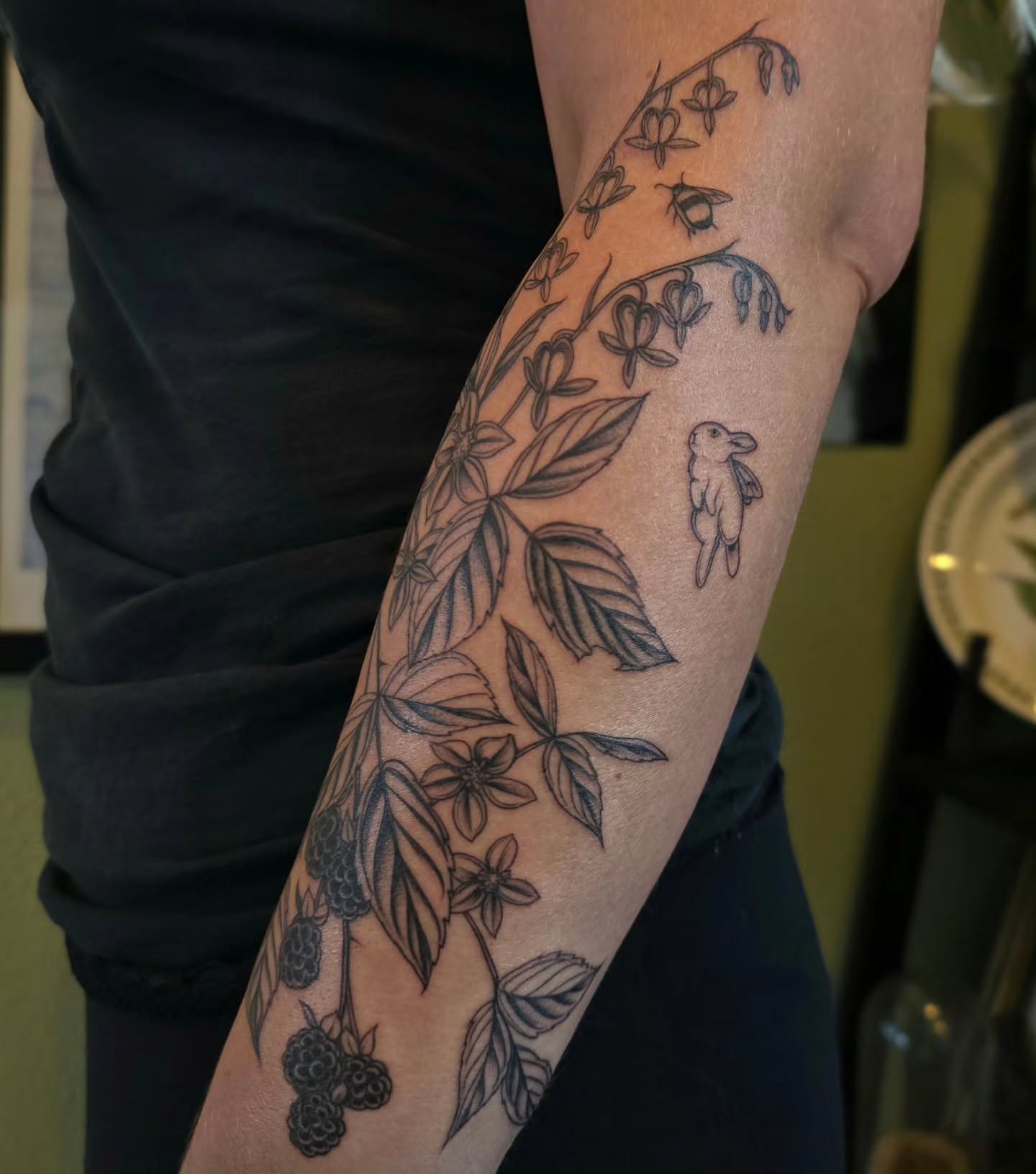 Bird and floral vine black and grey tattoo on the forearm by Sierra (cc) Klein