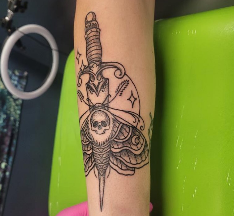 Sword and skull black and grey tattoo on the forearm by Wray Saulsberry