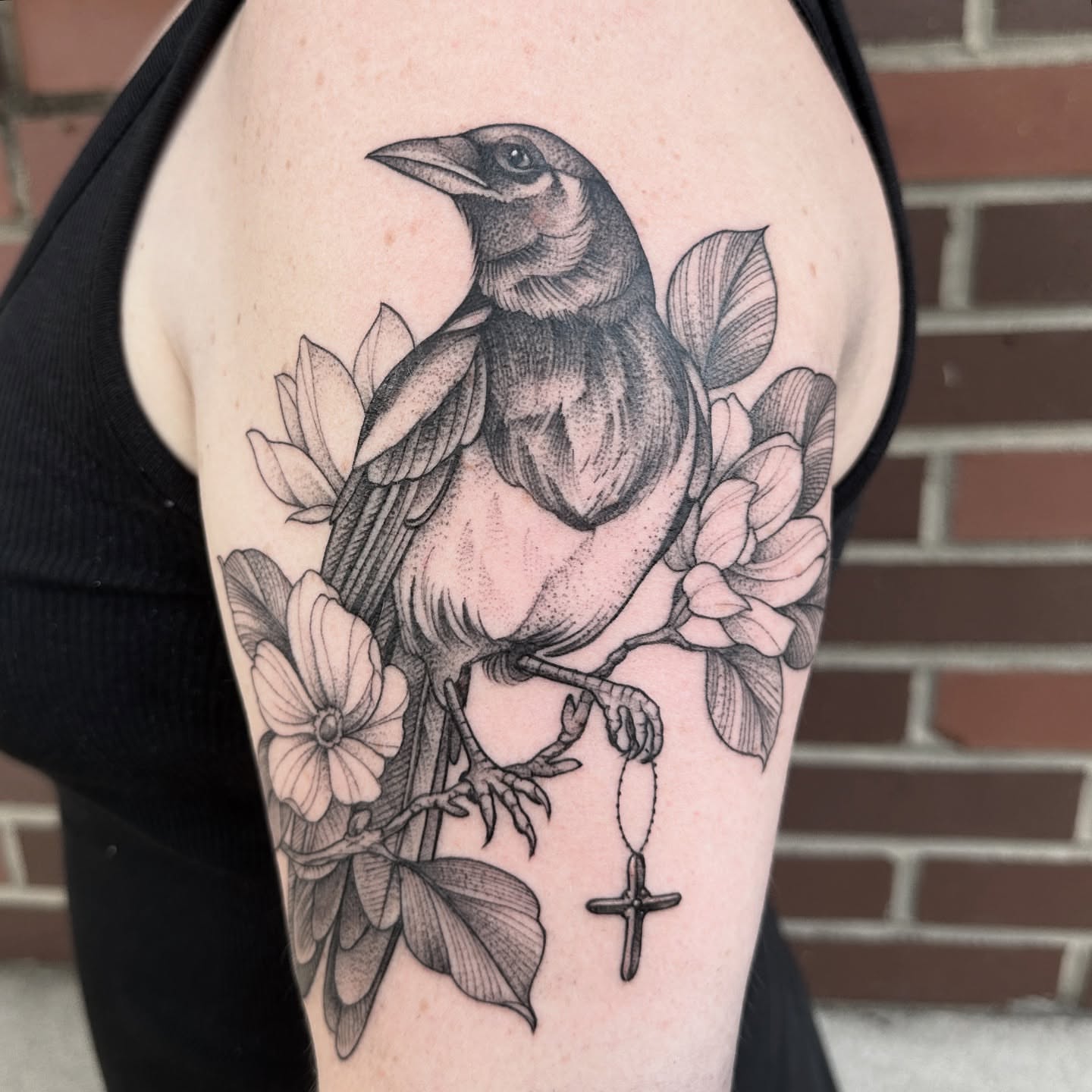 Crow and flowers dotwork tattoo on the upper arm by Robert McCollum