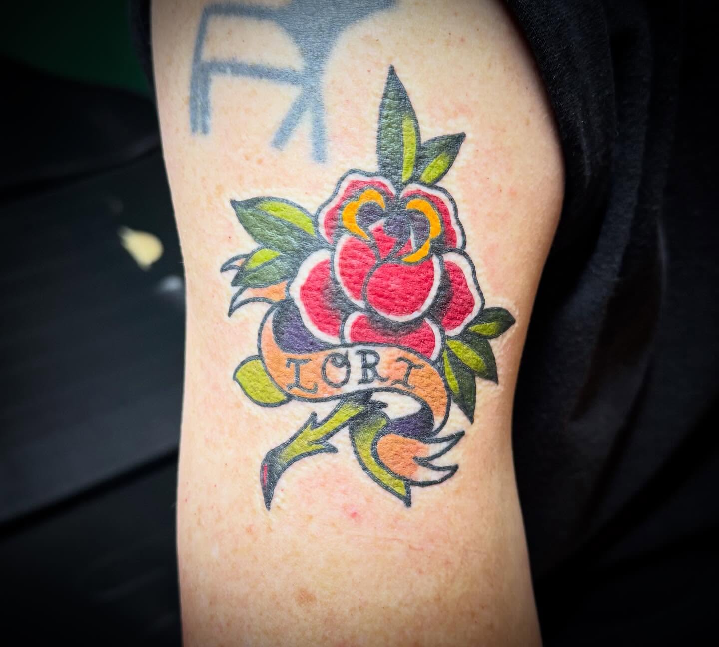 Flower with banner American traditional tattoo on the forearm by Jeremy Carson