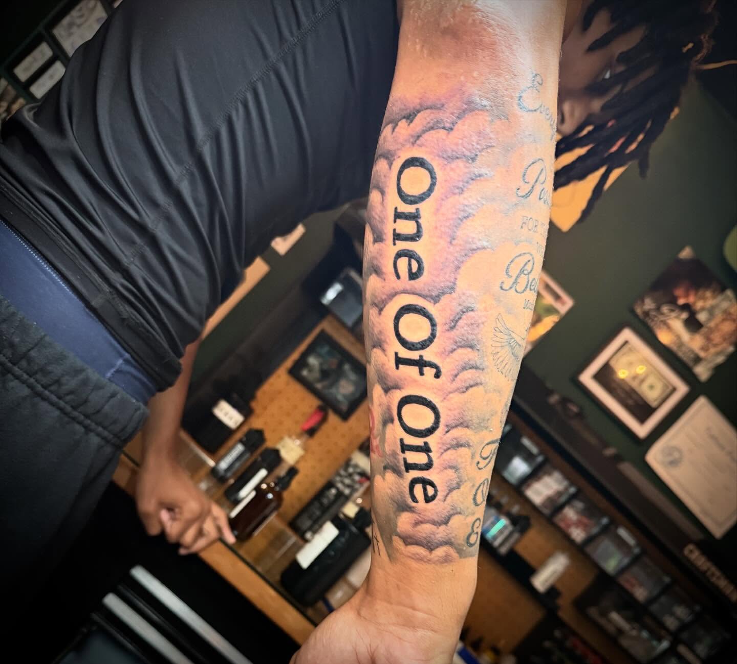 Clouds with text dotwork tattoo on the forearm by Jeremy Carson