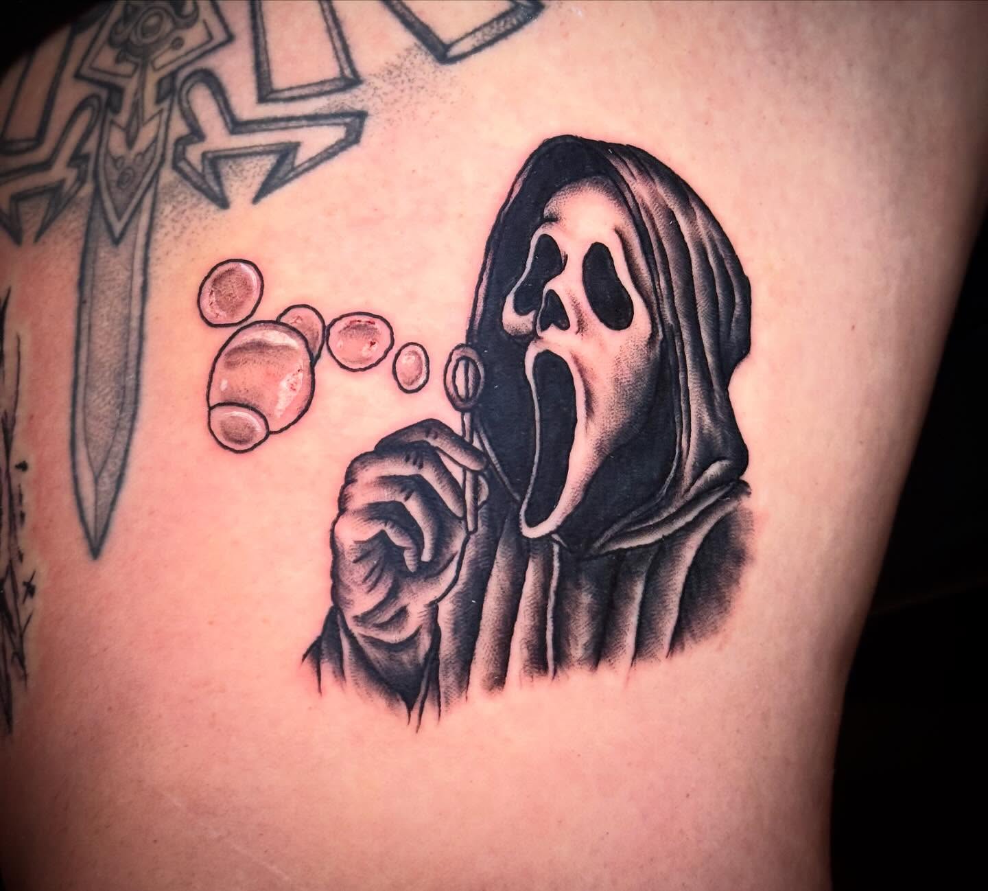 Scream ghost blowing bubbles black and grey tattoo on the thigh by Jeremy Carson