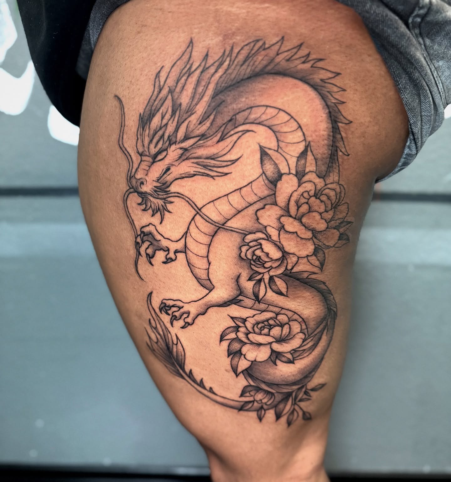 Dragon and roses realism tattoo on the thigh by Jess